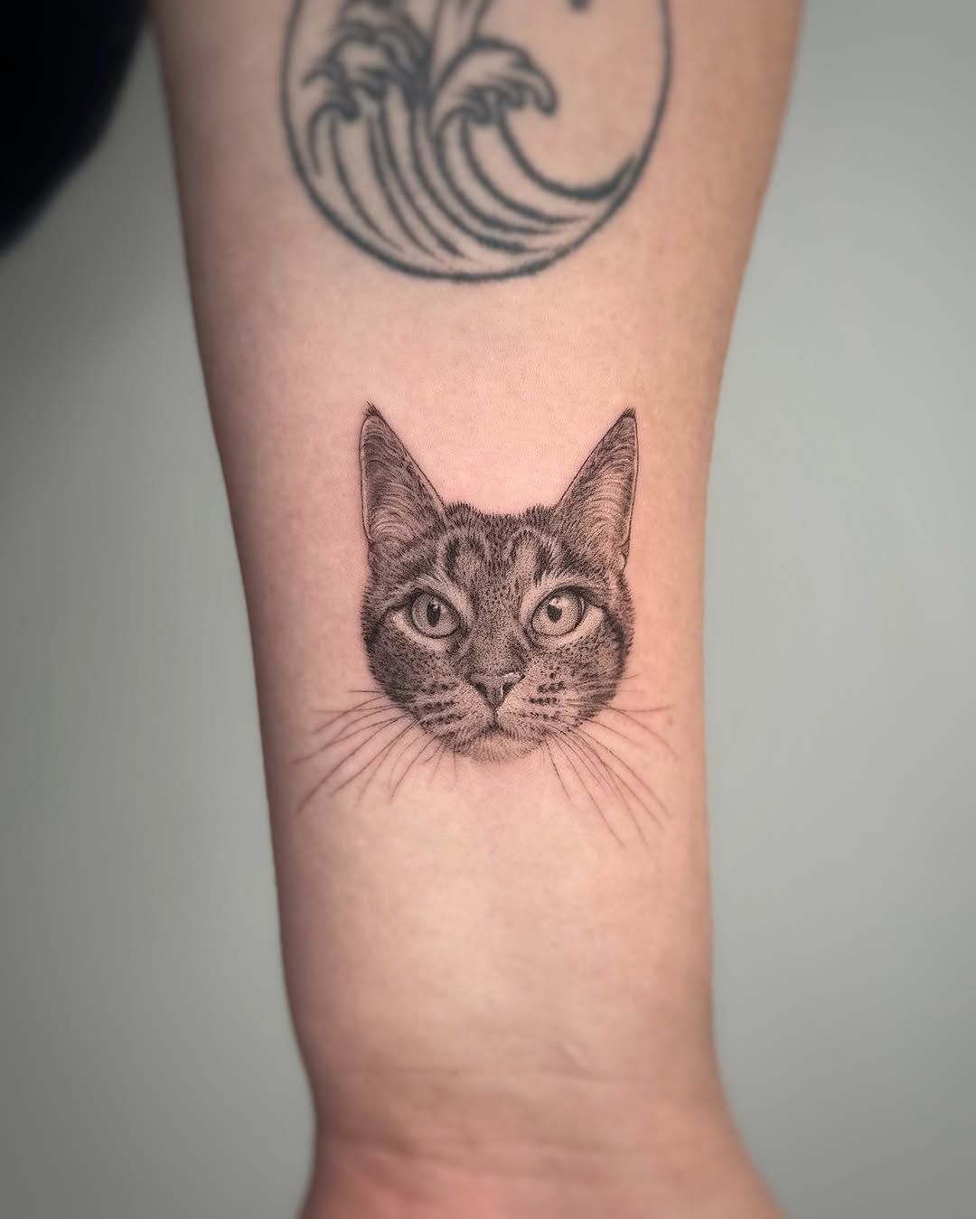 Cat portrait realism tattoo on the forearm by Lea Burkard, Berkeley, California