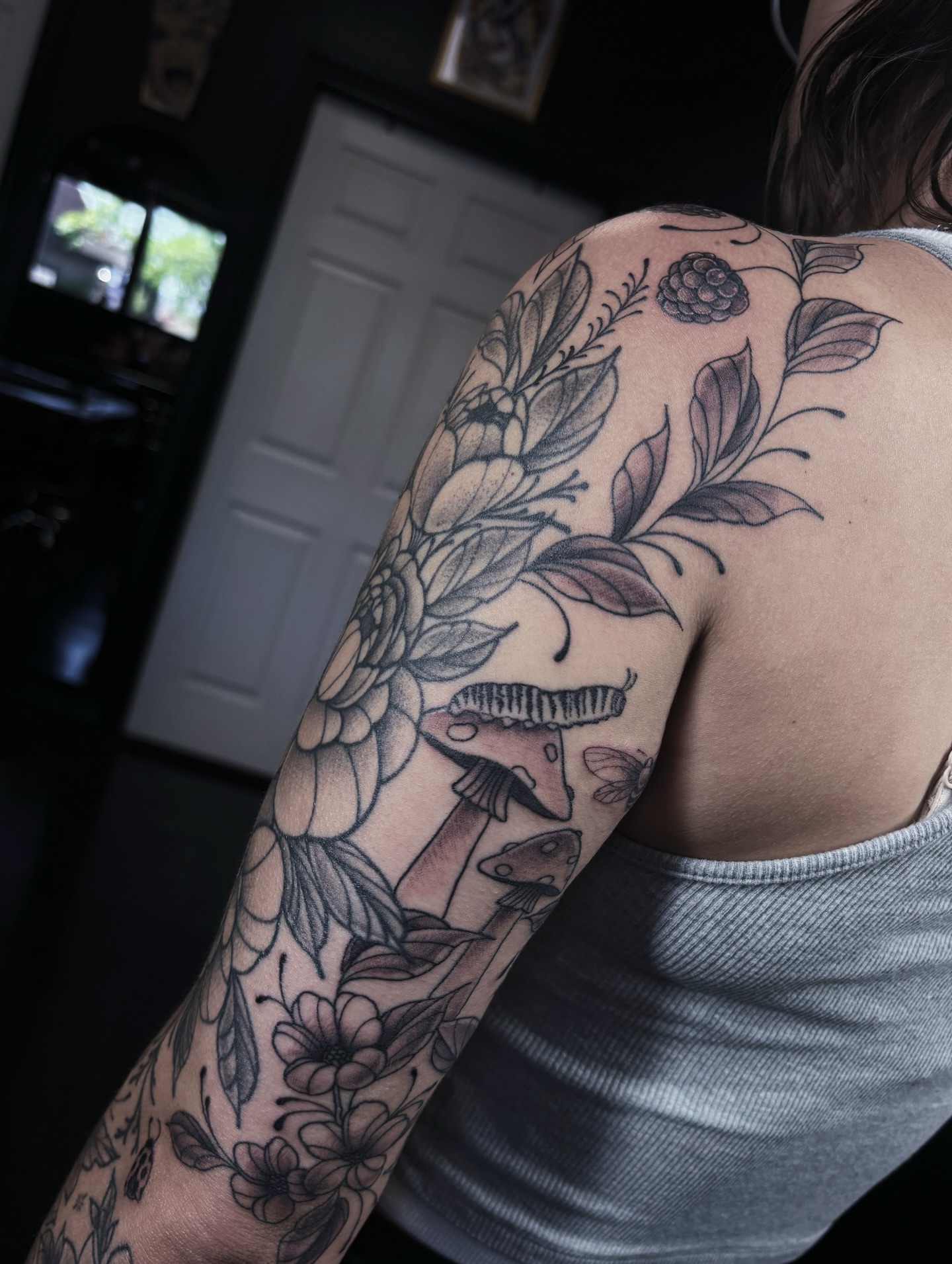 Floral bouquet black and grey tattoo on the shoulder by Fine Line Tattoo Artist