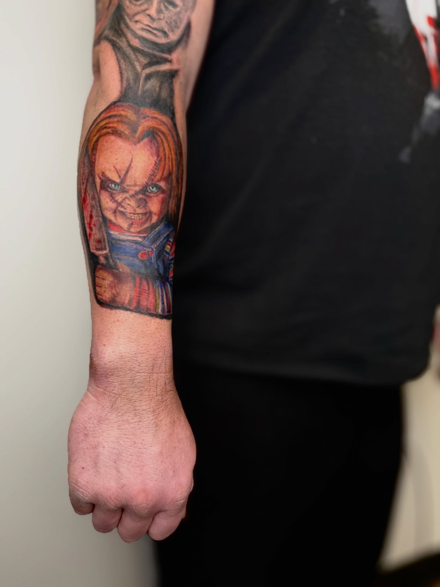 Chucky doll realism tattoo on the forearm by Mackenzie