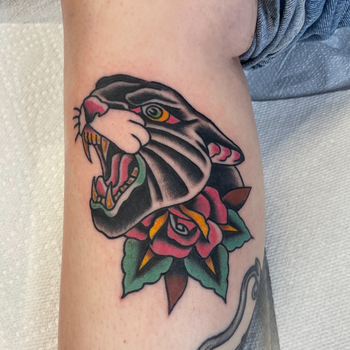 Panther and rose American traditional tattoo on the forearm by Greg De Hoot, Youngsville, North Carolina