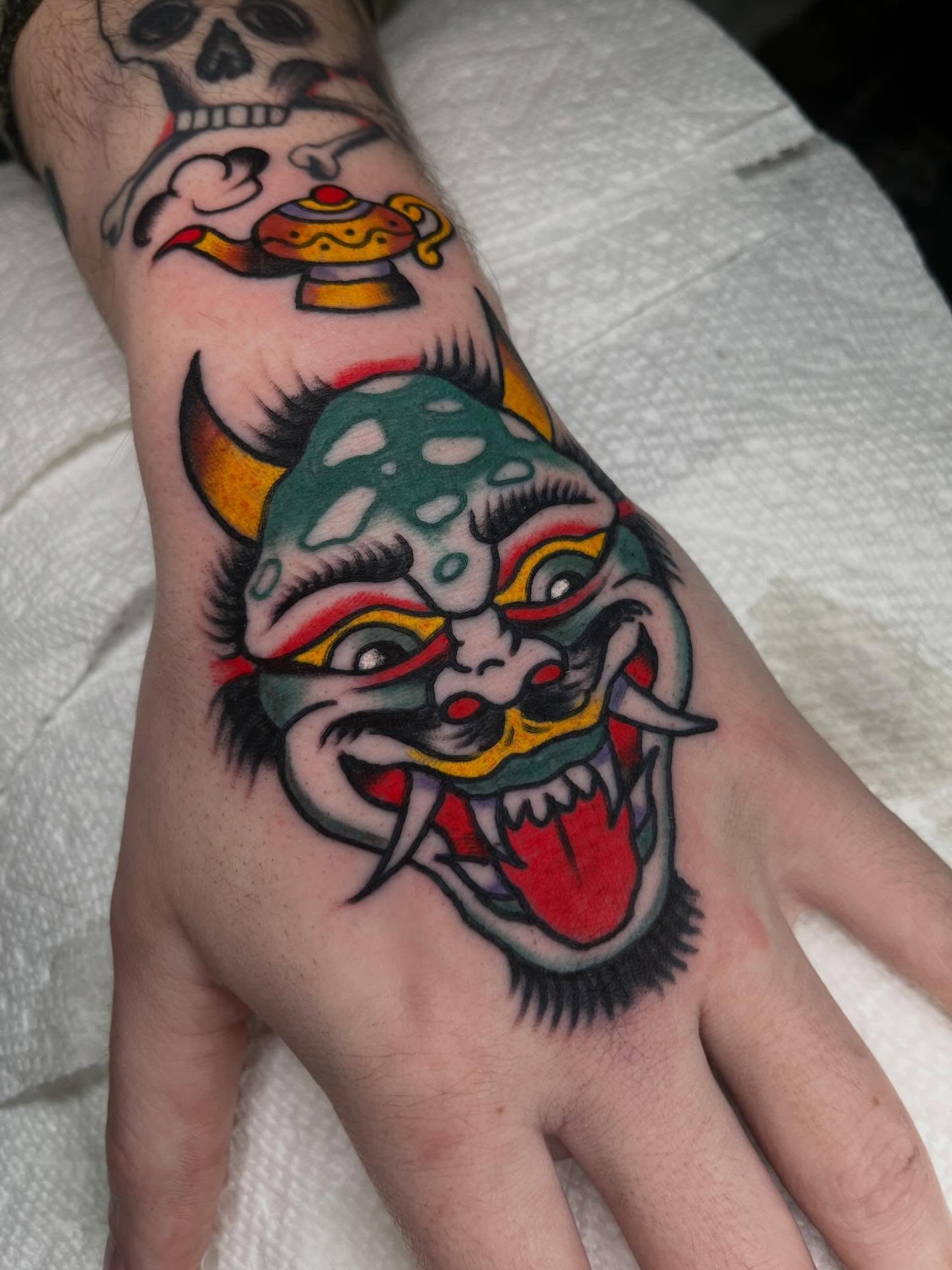 Lion mask American traditional tattoo on the hand by Charlie Ostrom, Durham, North Carolina