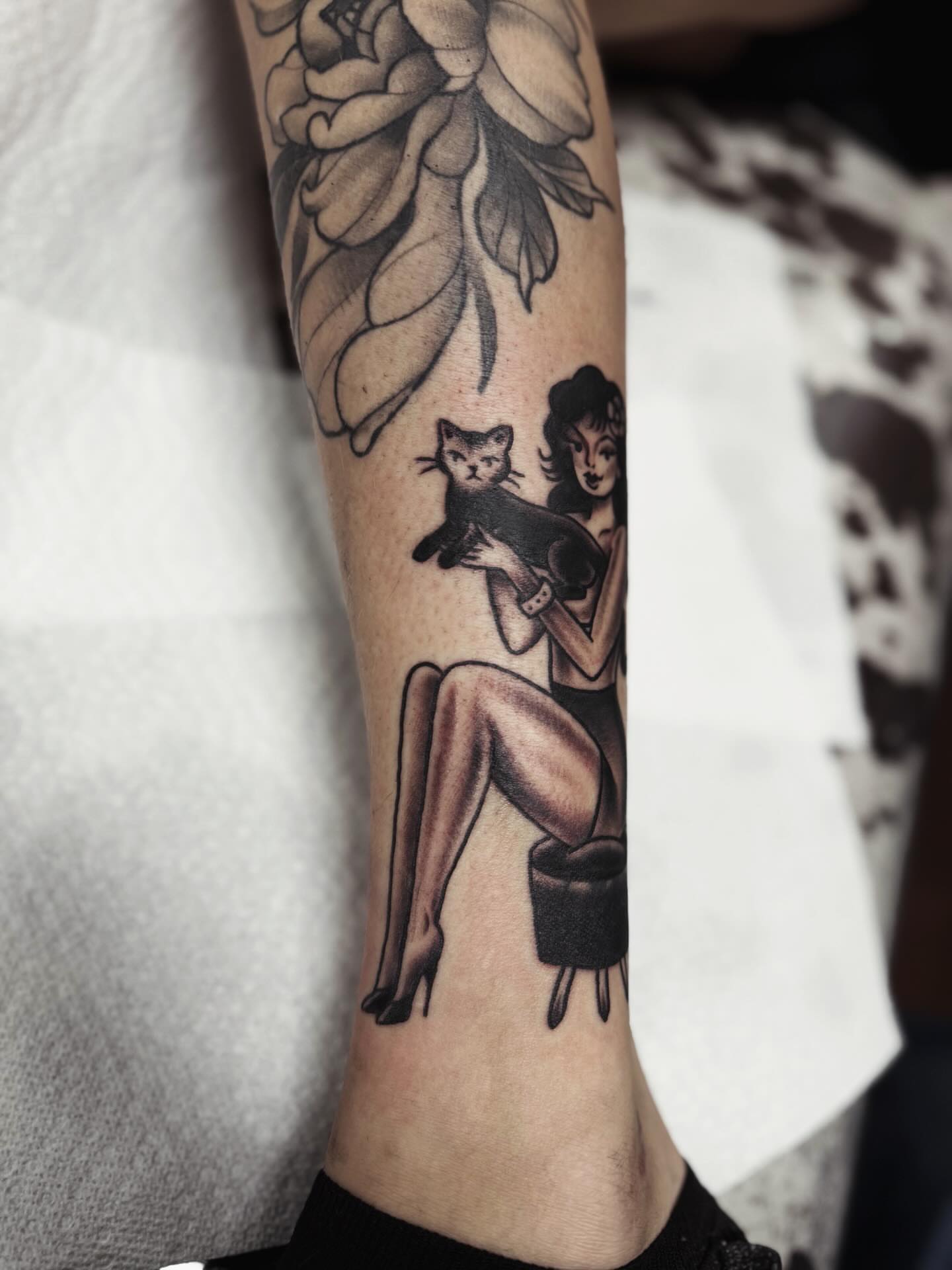 Woman holding cat American traditional tattoo on the forearm by @amandahowtattoo