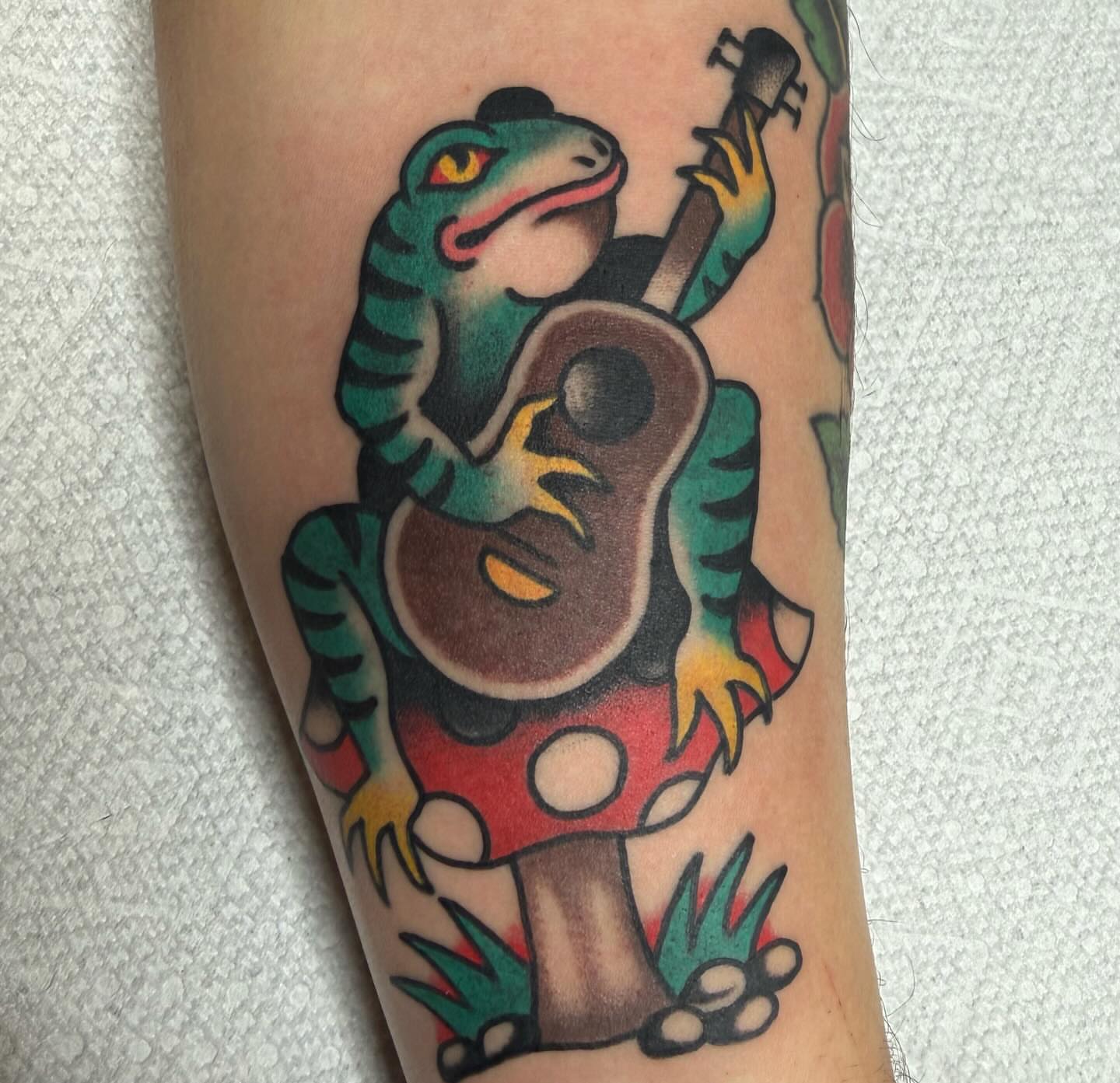 Lizard playing guitar American traditional tattoo on the forearm by ༺tessa༻