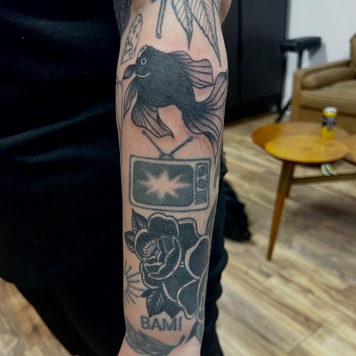 Goldfish, TV, roses black and grey tattoo on the forearm by Victorian Coleman
