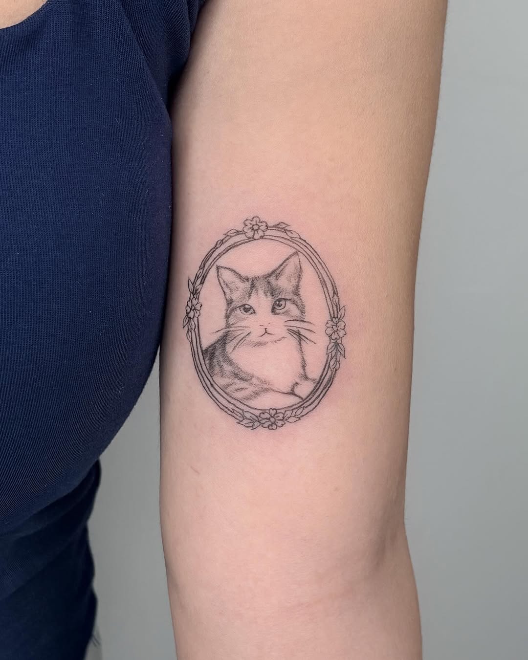 Cat portrait in frame realism tattoo on the forearm by Jinz