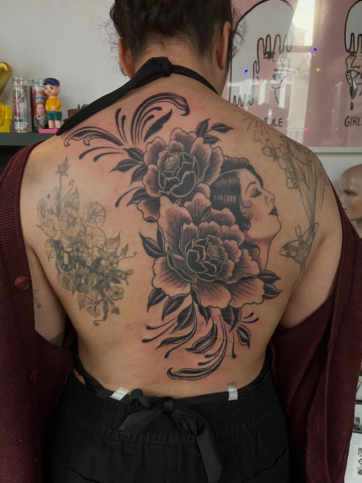 Floral and woman portrait realism tattoo on the back by Maddy Anthony