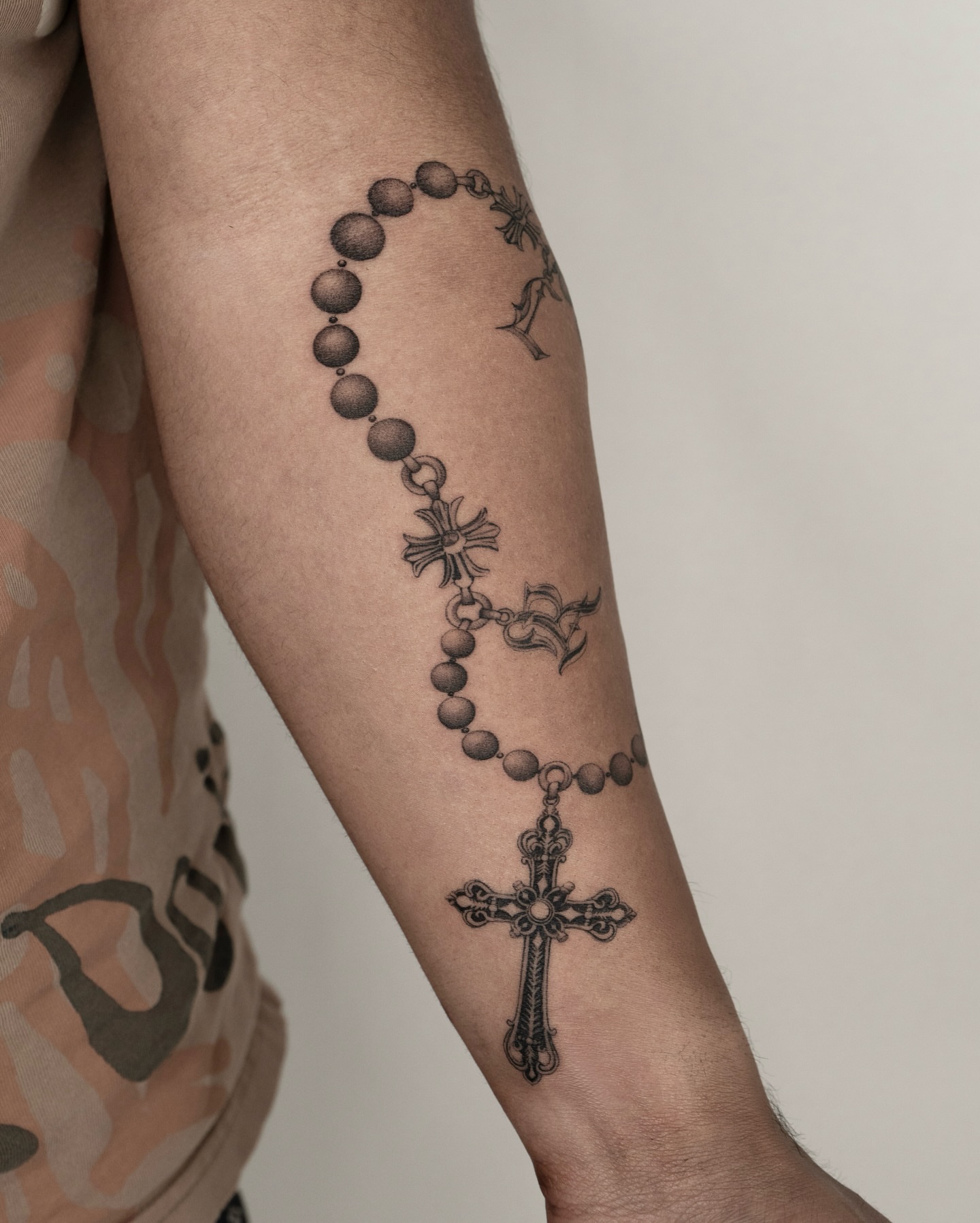 Rosary black and grey tattoo on the forearm by t y, t a t t o o a r t i s t