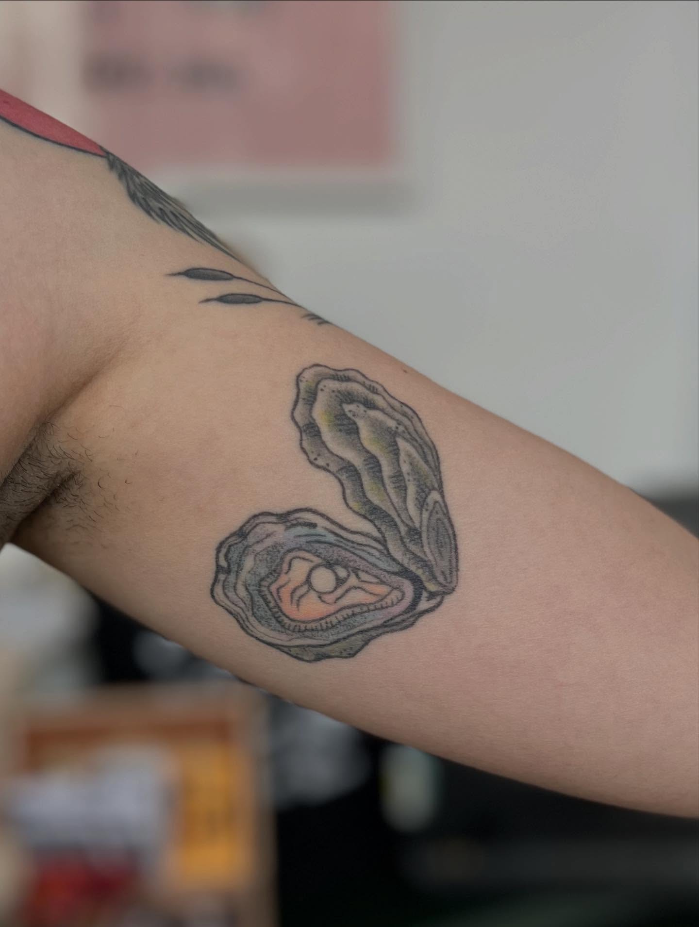 Oyster realism tattoo on the forearm by Maddy Anthony