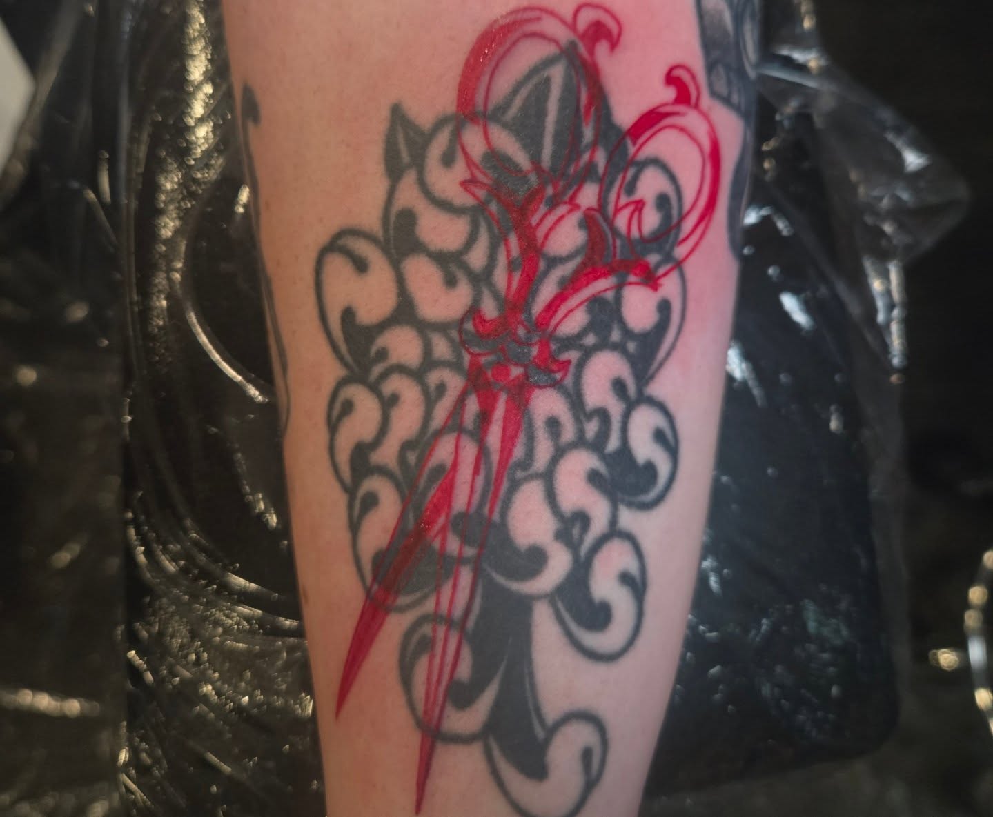 Sword and swirls black and grey tattoo on the forearm by Lane