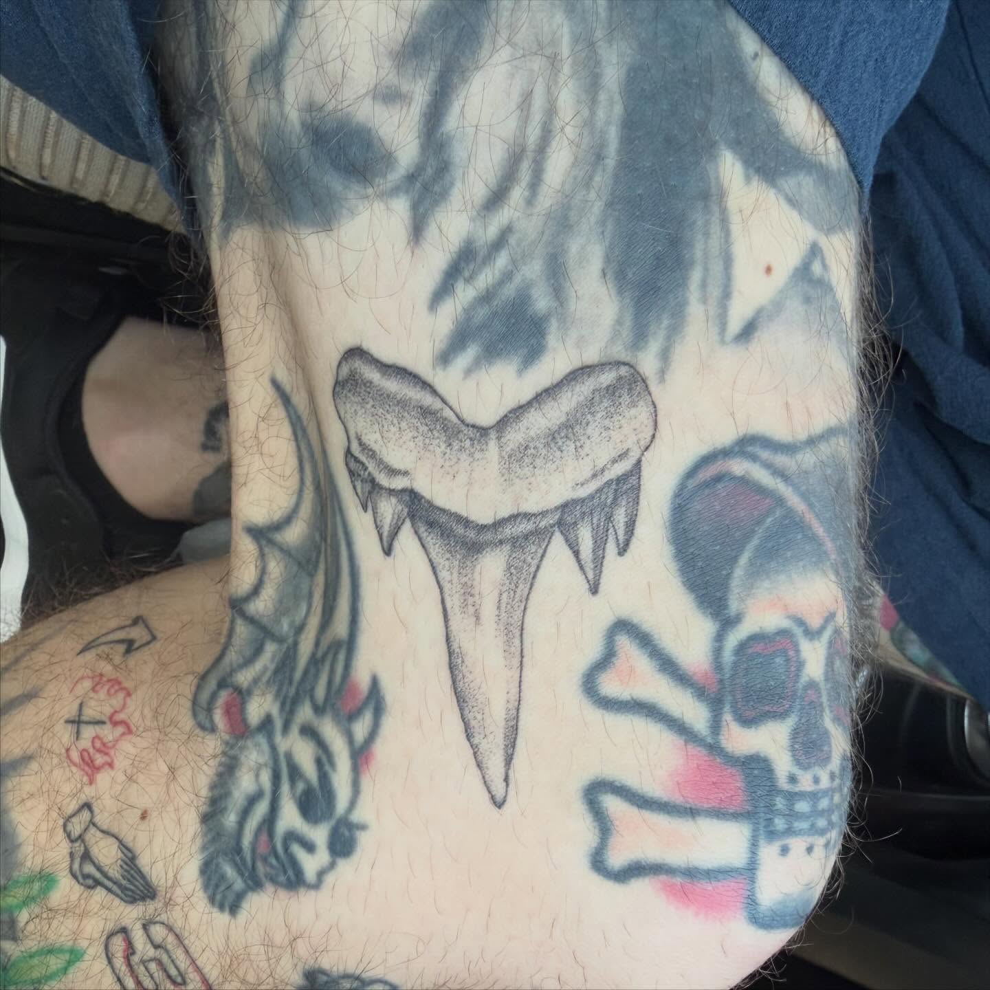 Shark tooth black and grey tattoo on the thigh by Matt Hattaway