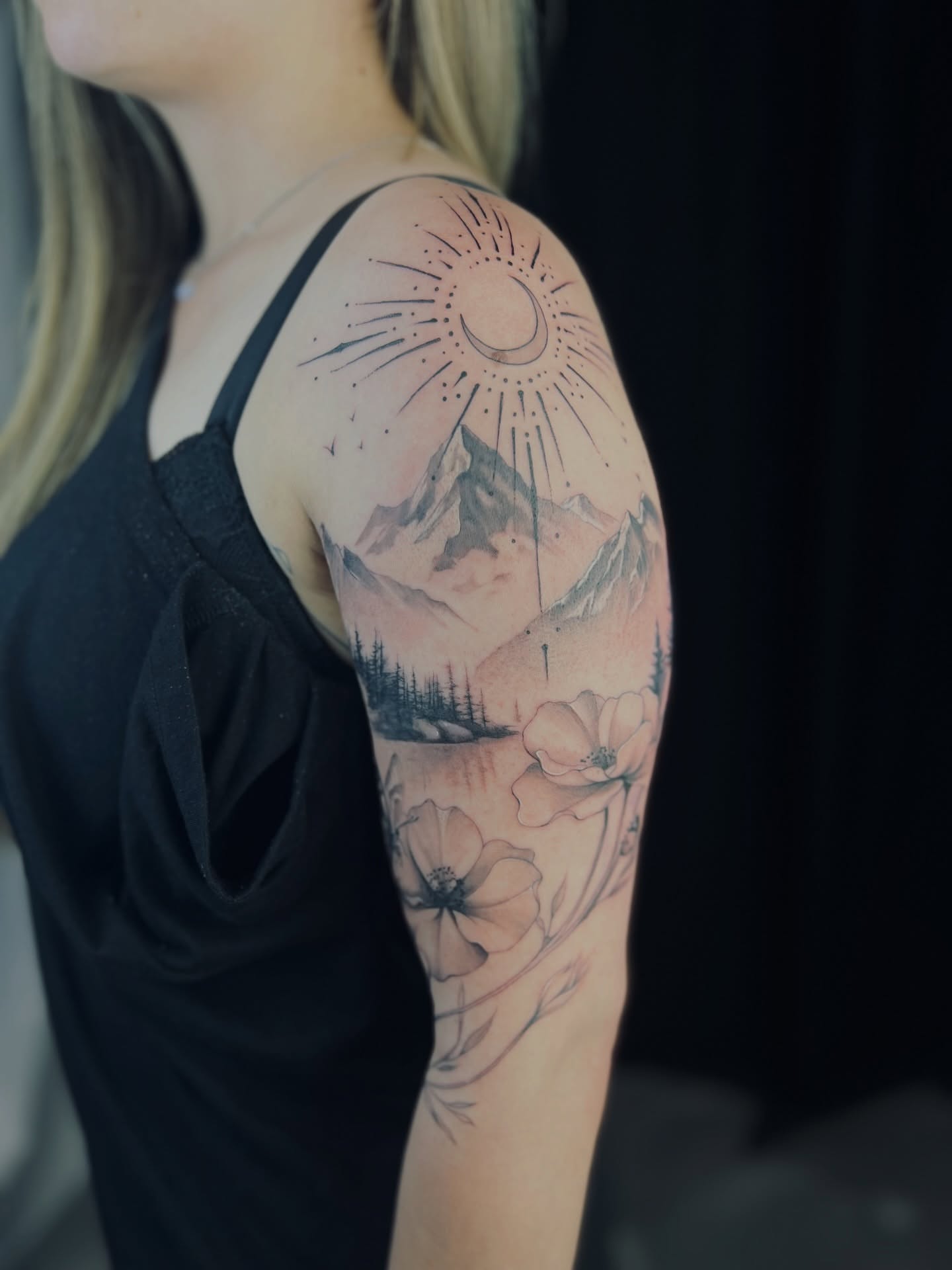 Mountains and flowers dotwork tattoo on the upper arm by Apologies tattoo studios.