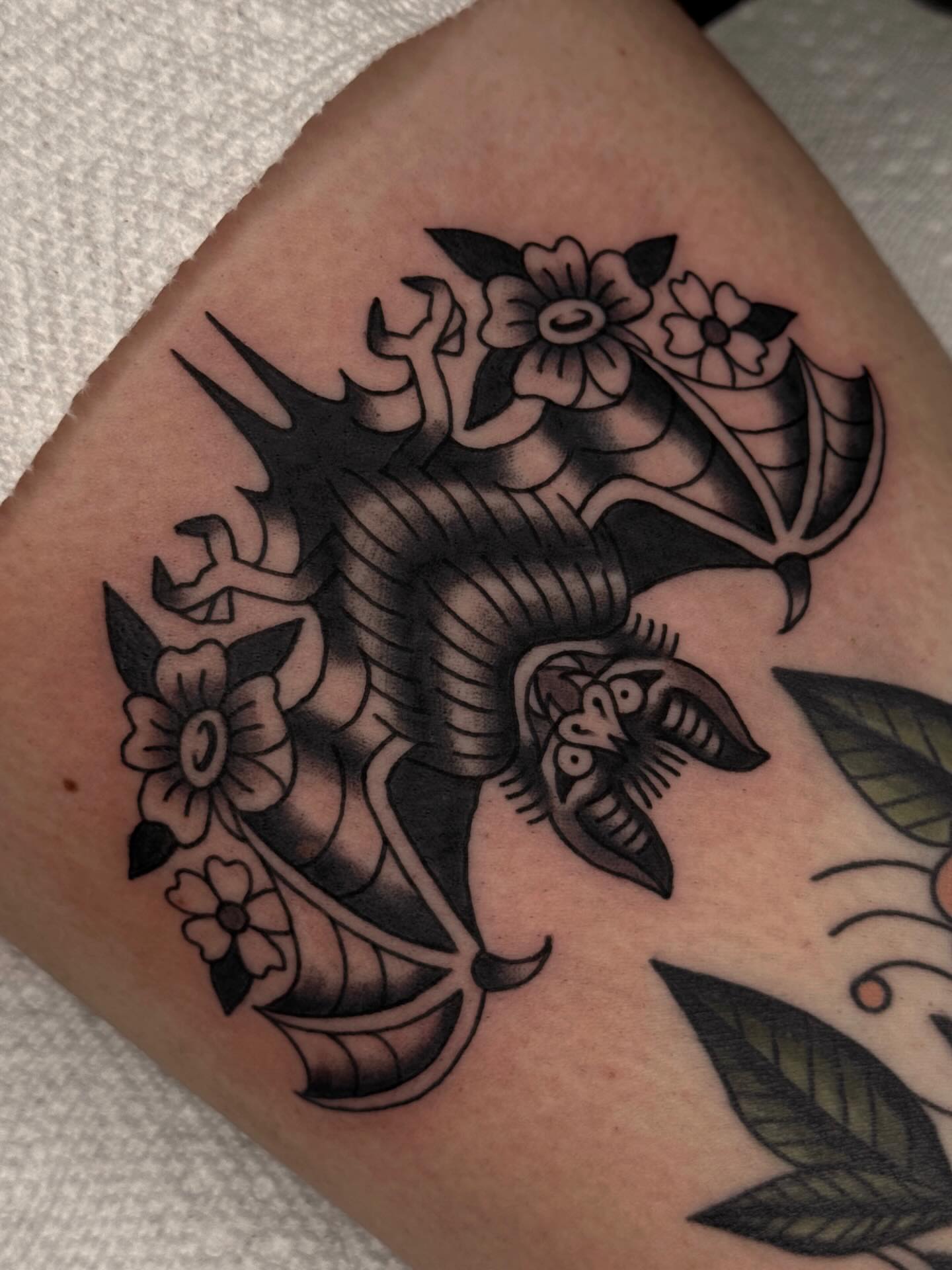 Bat and flowers American traditional tattoo on the forearm by Bridgette Carberry