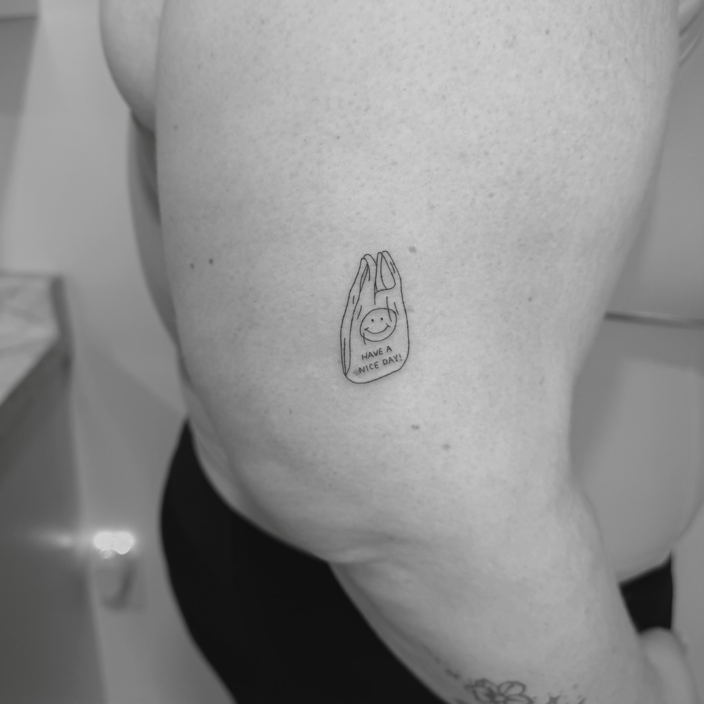 Plastic bag with smiley face minimalist tattoo by Jessica, Cheektowaga, New York