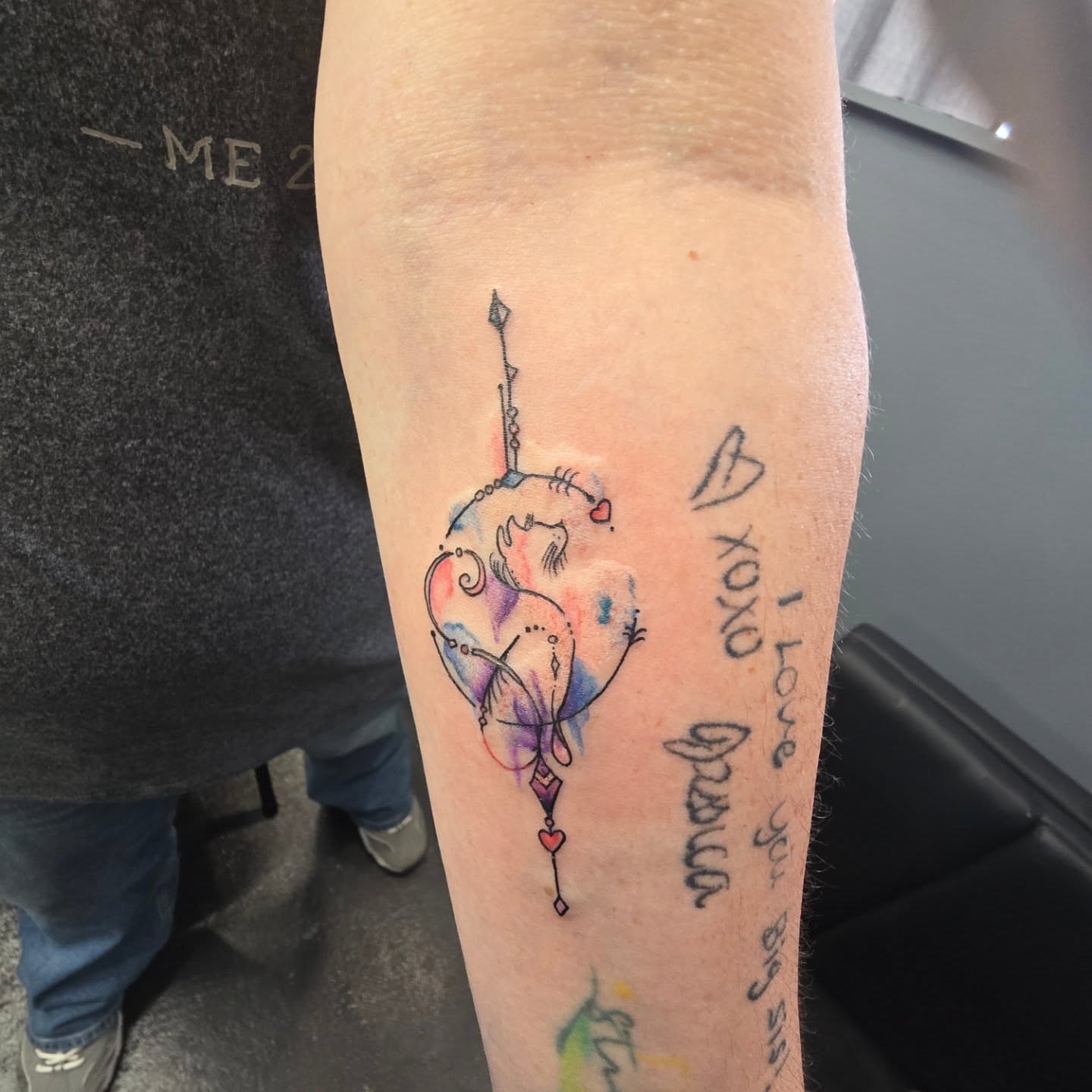 Cat and arrow watercolor tattoo on the forearm by Maddox Kitson🕷