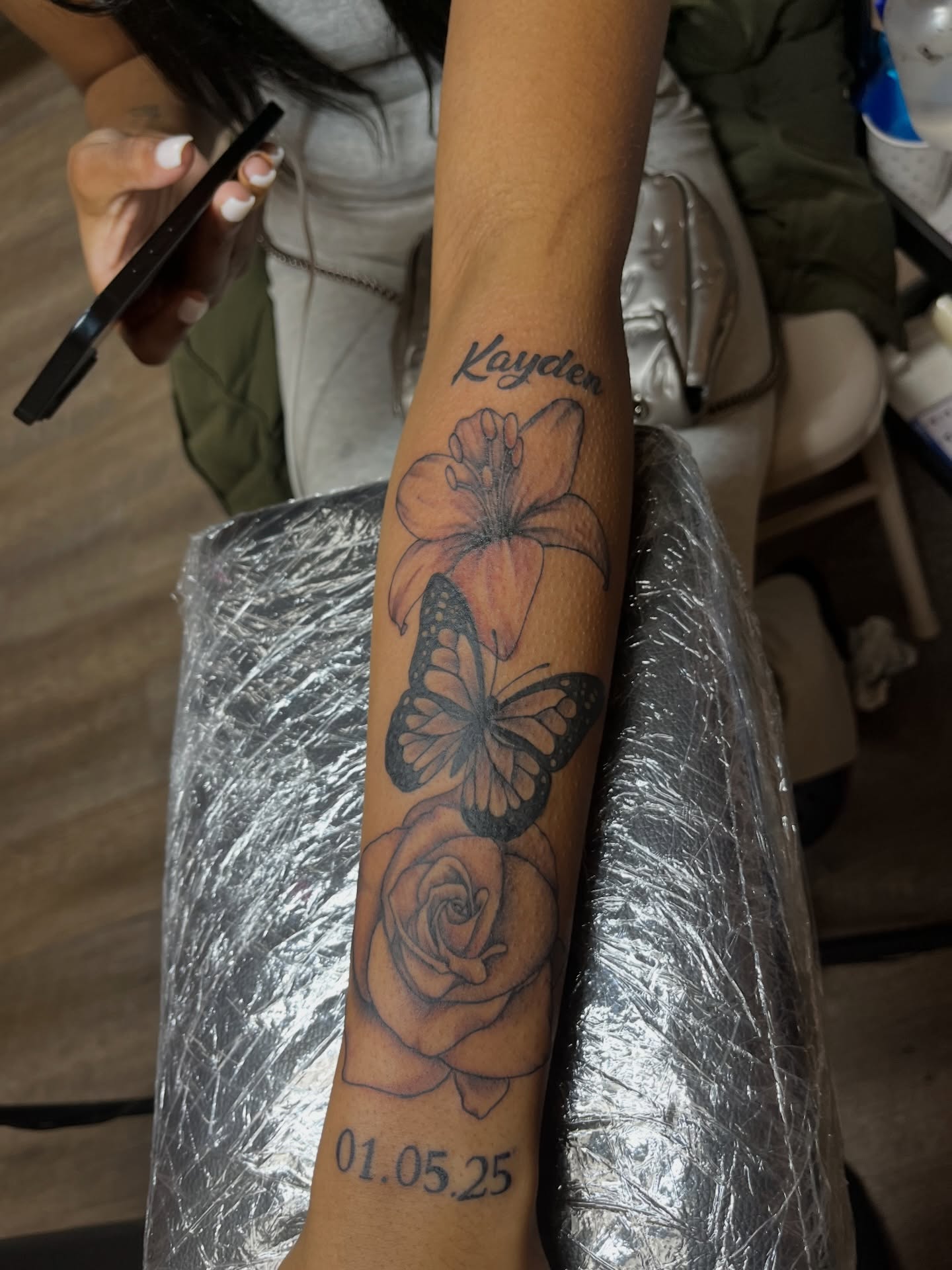 Flower and butterfly black and grey tattoo on the forearm by Tam💟👩🏽‍🎨