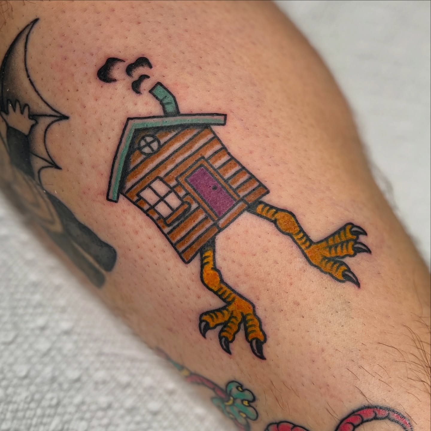 House with legs new school tattoo on the forearm by Andrew Storm