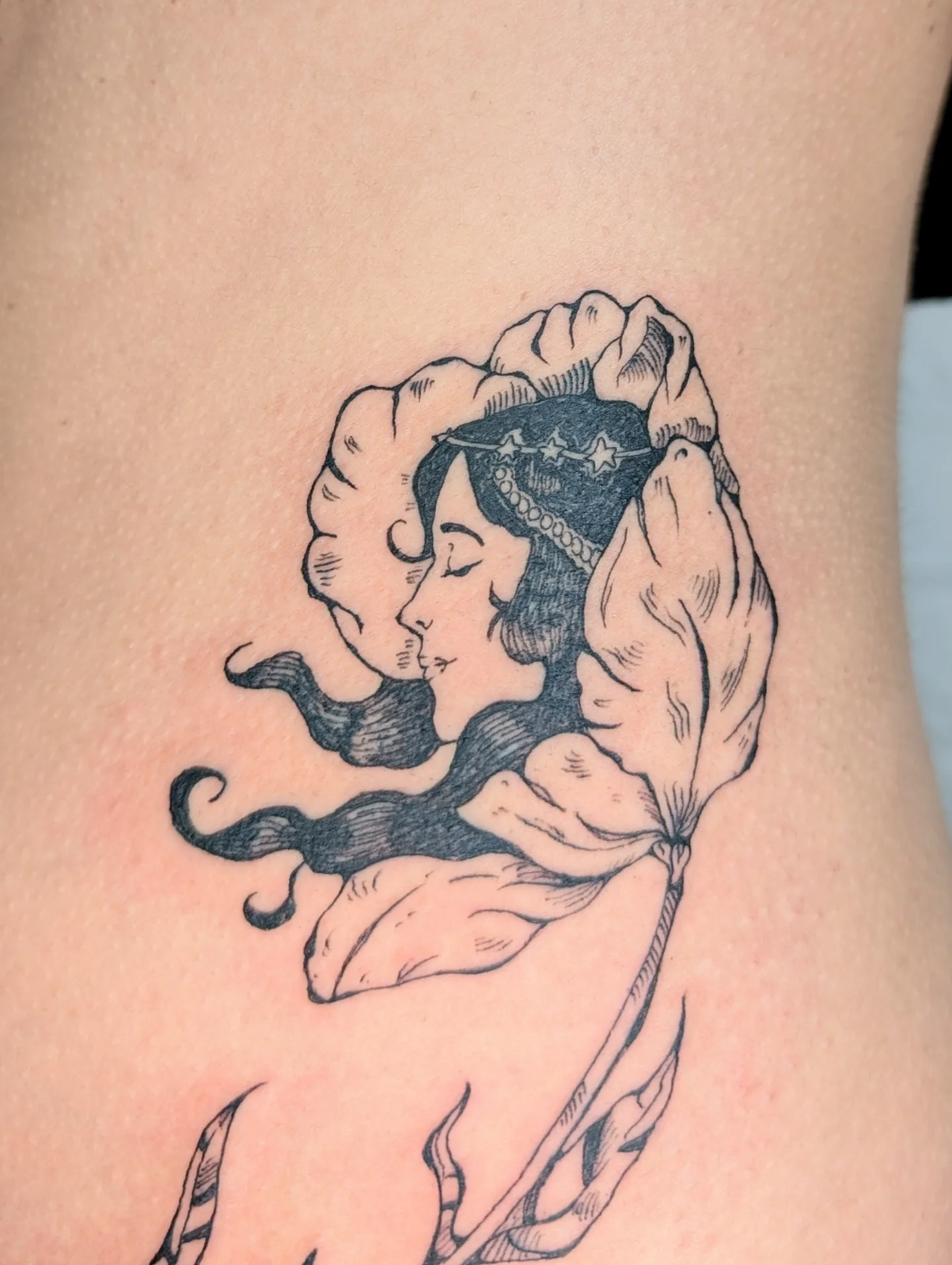 Woman with flower crown black and grey tattoo on the torso by mila