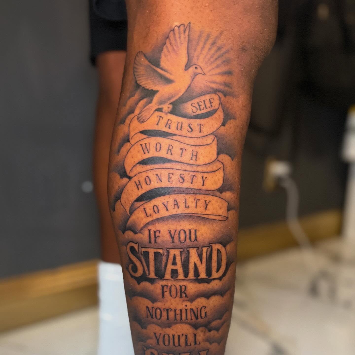 Dove and scroll black and grey tattoo on the forearm by Marquis Neal