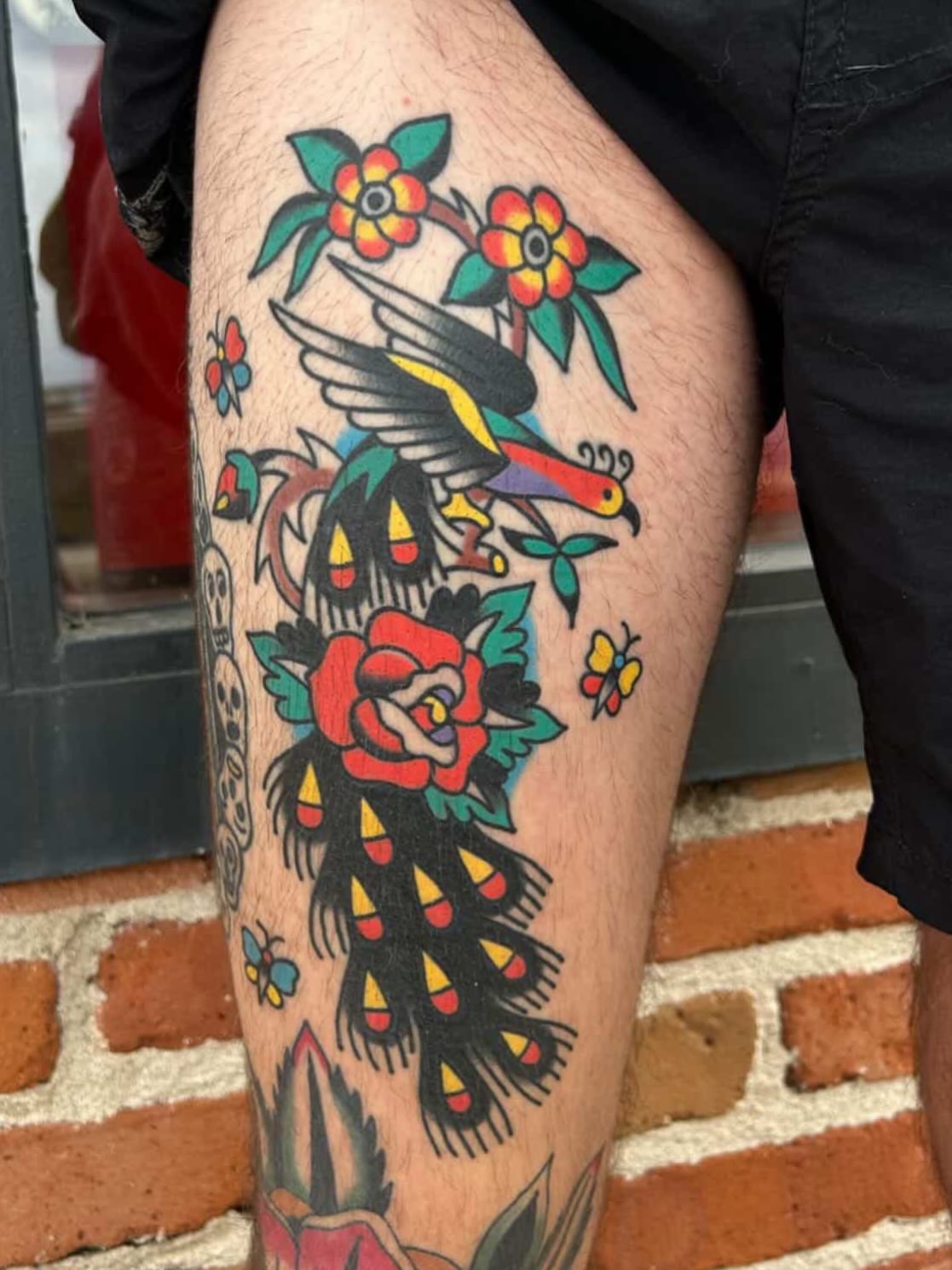 Peacock and flowers American traditional tattoo on the thigh by Traditional Tattooing