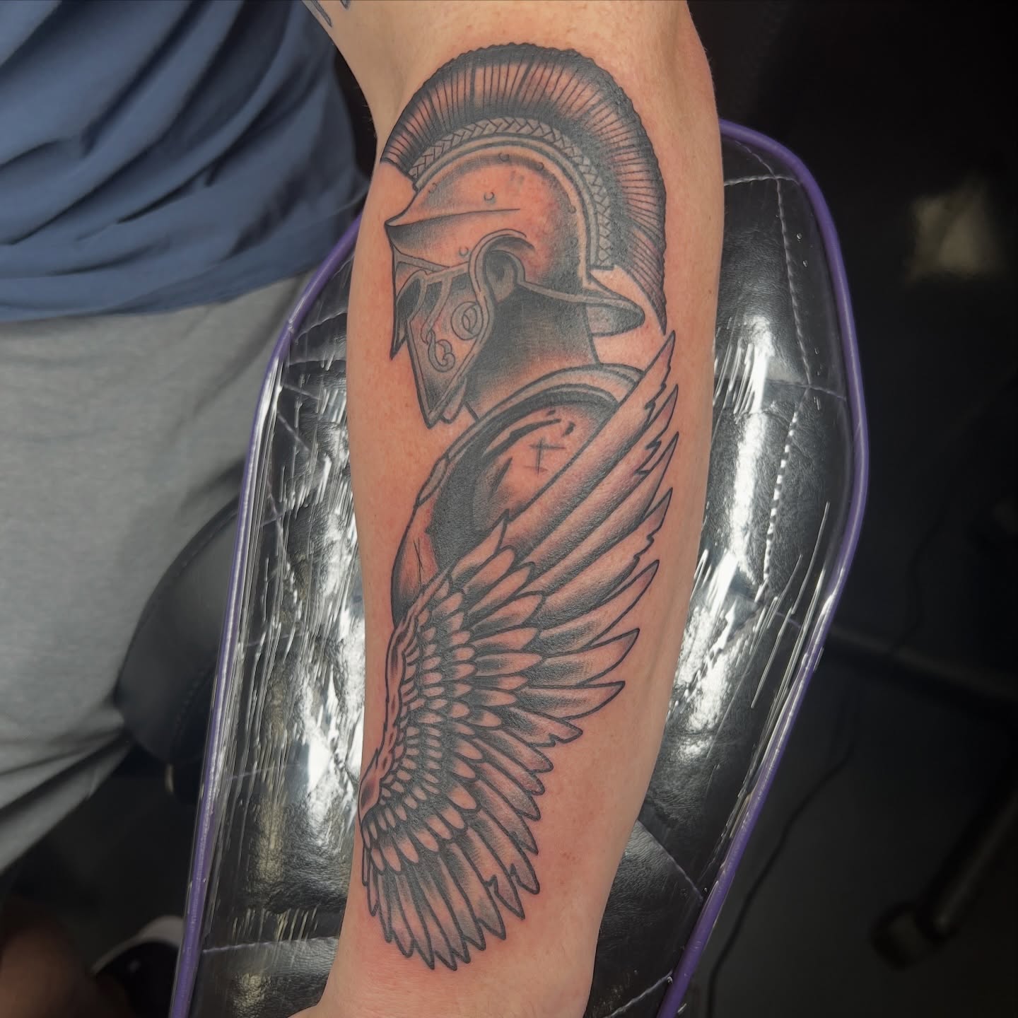 Winged warrior helmet black and grey tattoo on the forearm by Brian Mock