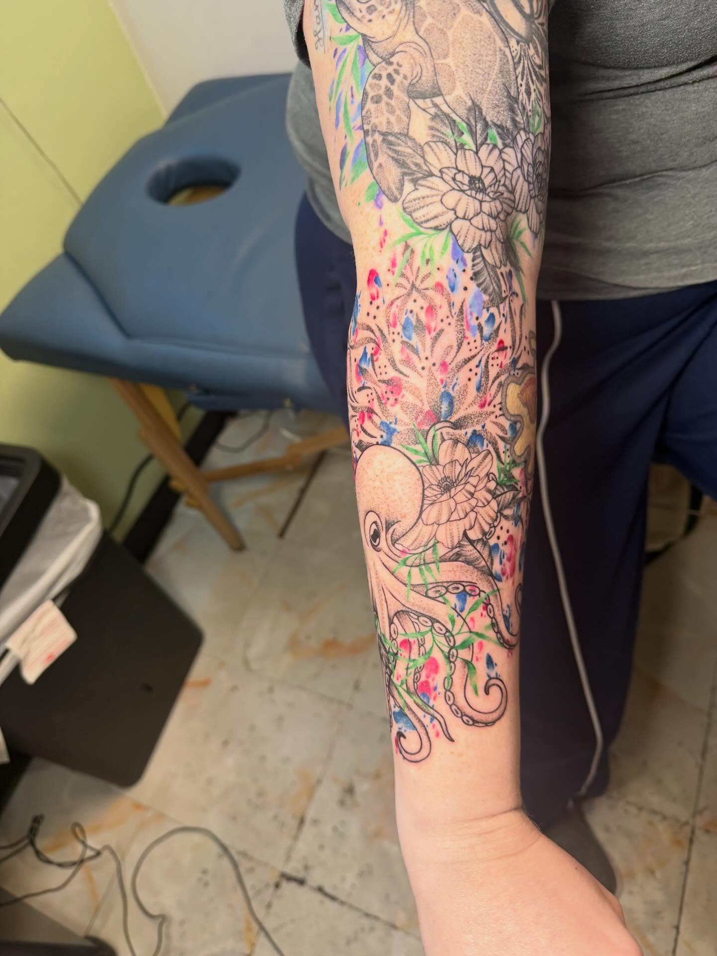 Octopus and floral watercolor tattoo on the forearm by Abby