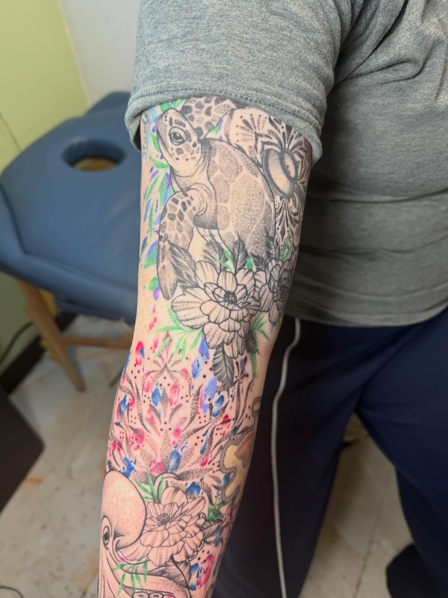 Sea turtle and floral dotwork tattoo on the forearm by Abby