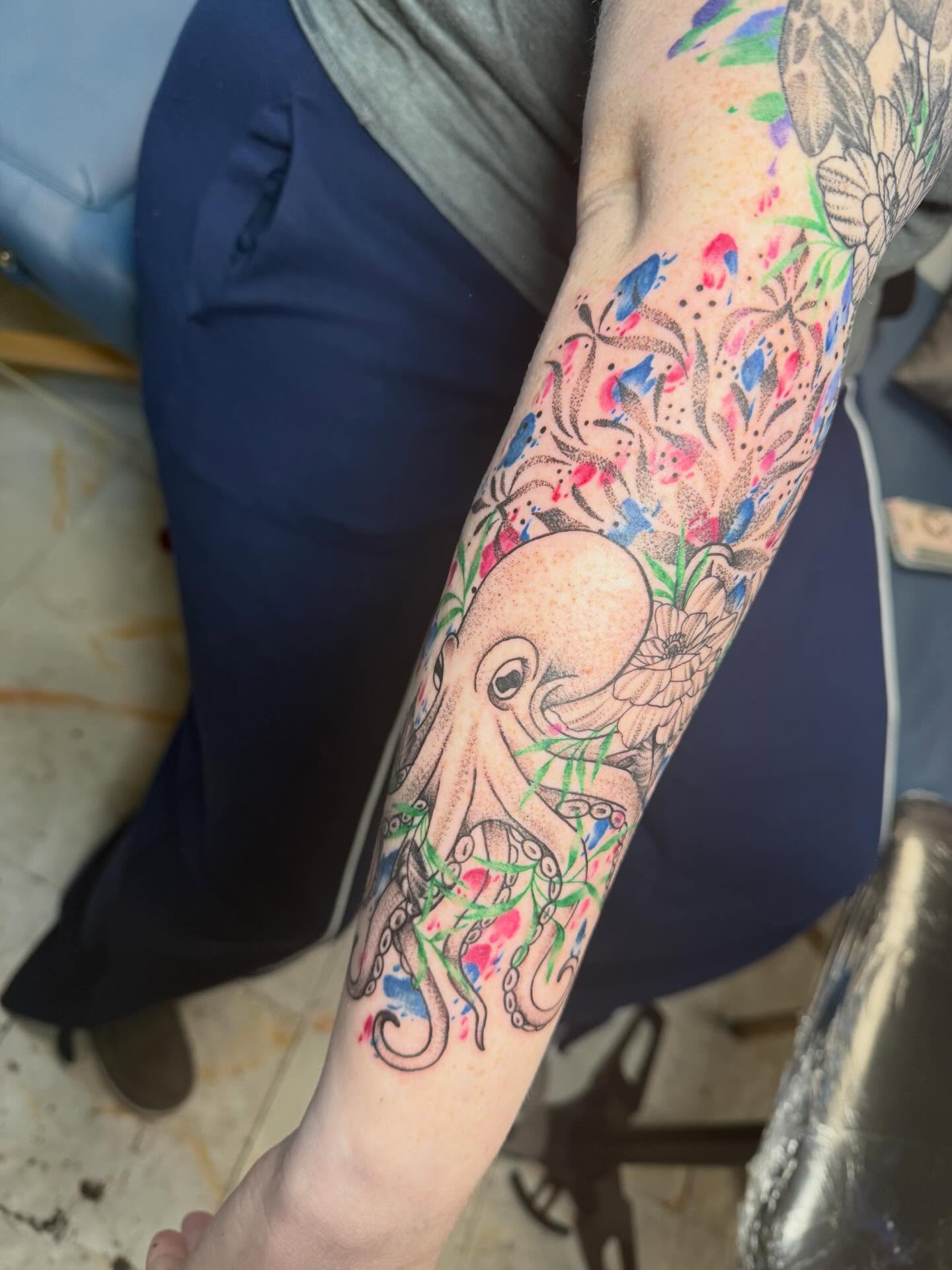 Octopus and floral watercolor tattoo on the forearm by Abby