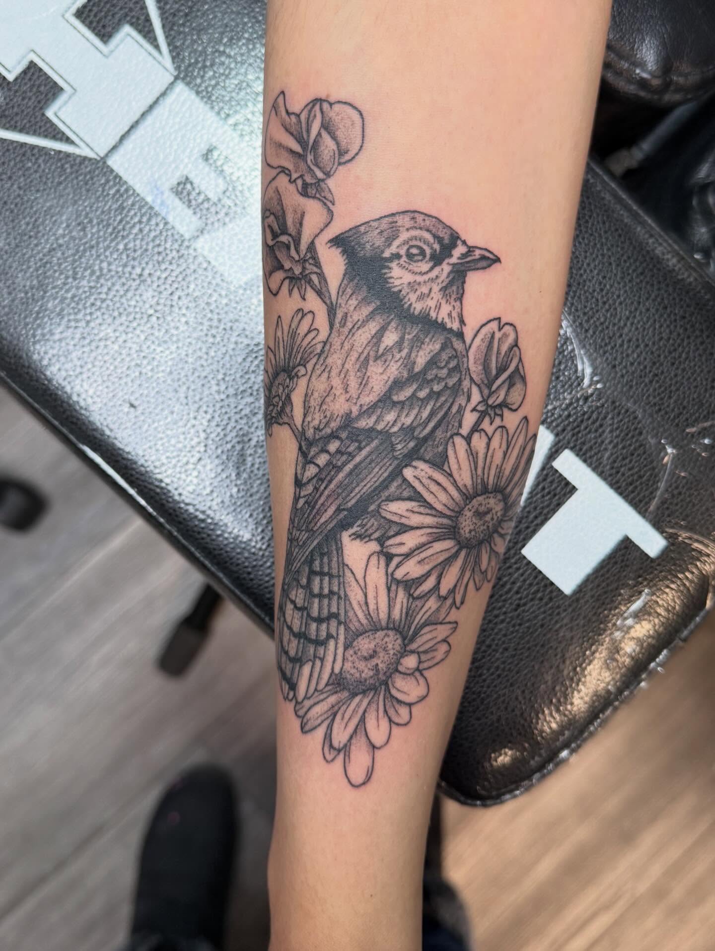 Bird and flowers black and grey tattoo on the forearm by Elena