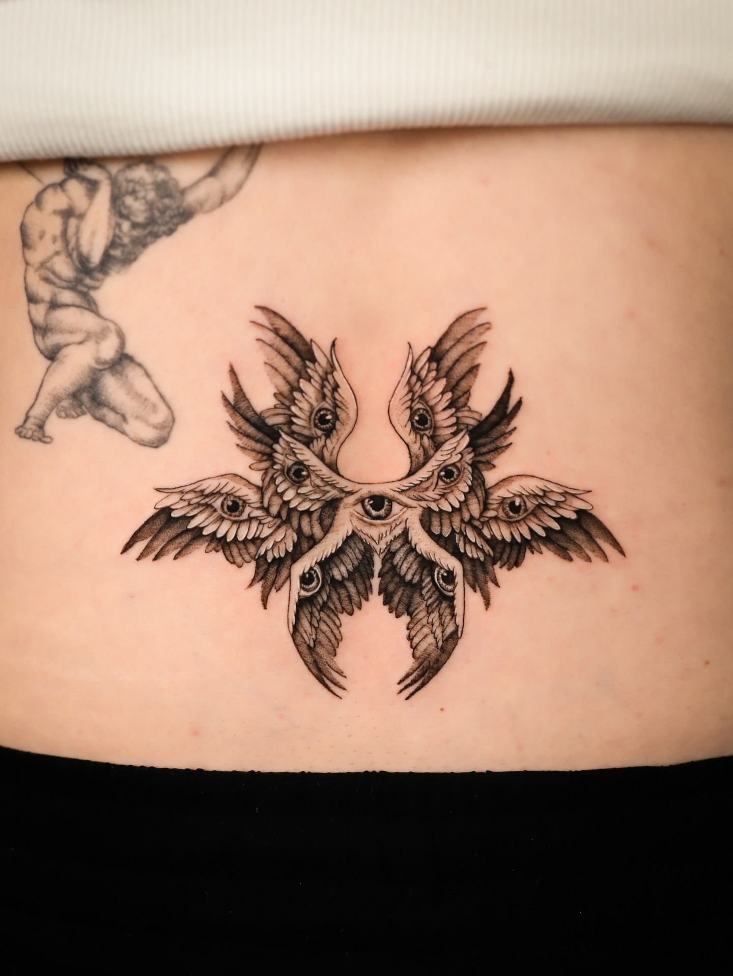 Moths with eyes geometric tattoo on the torso by Cyn