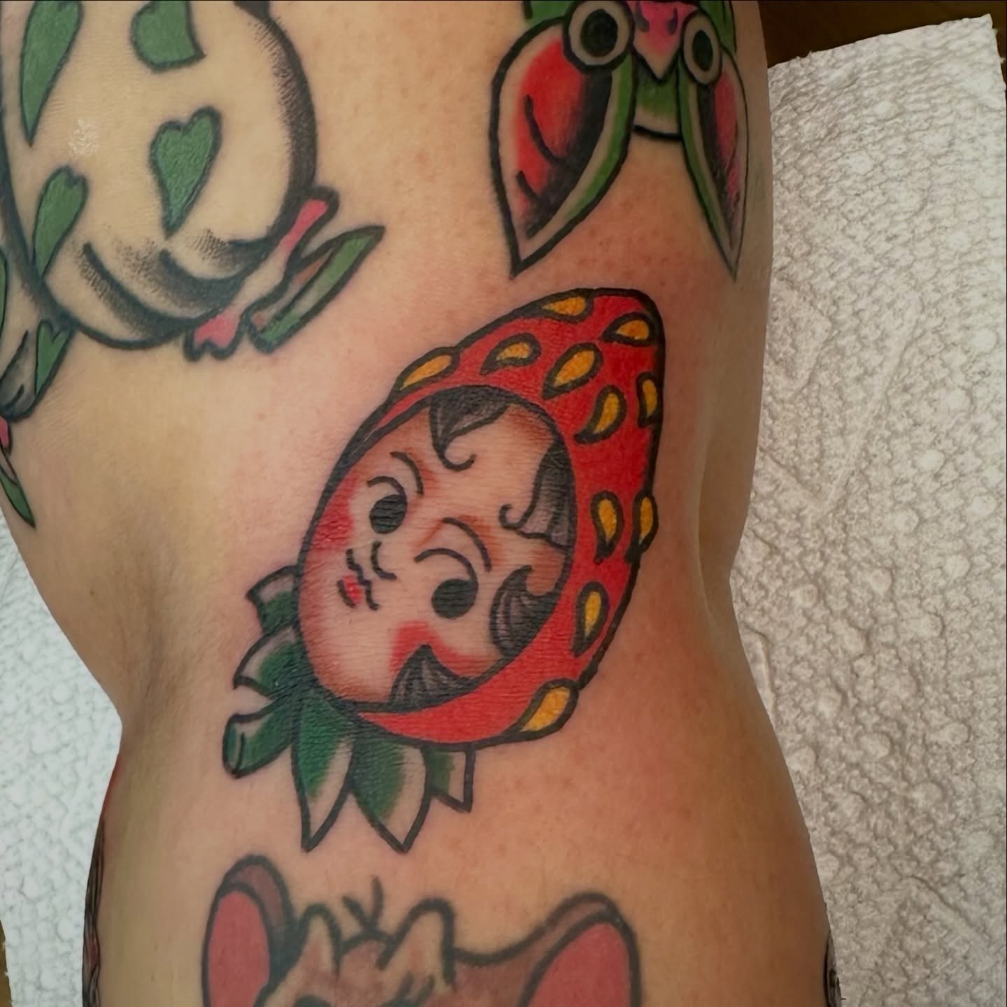 Strawberry character American traditional tattoo on the forearm by Josh Robinson