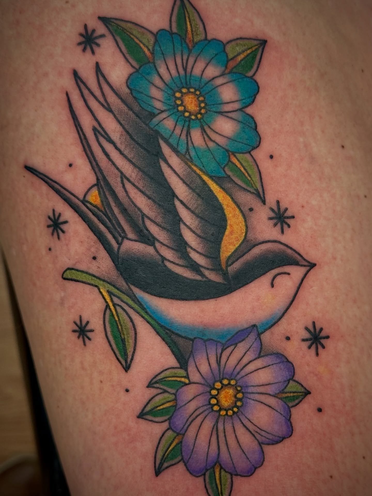 Bird and flowers American traditional tattoo on the thigh by Josh Robinson