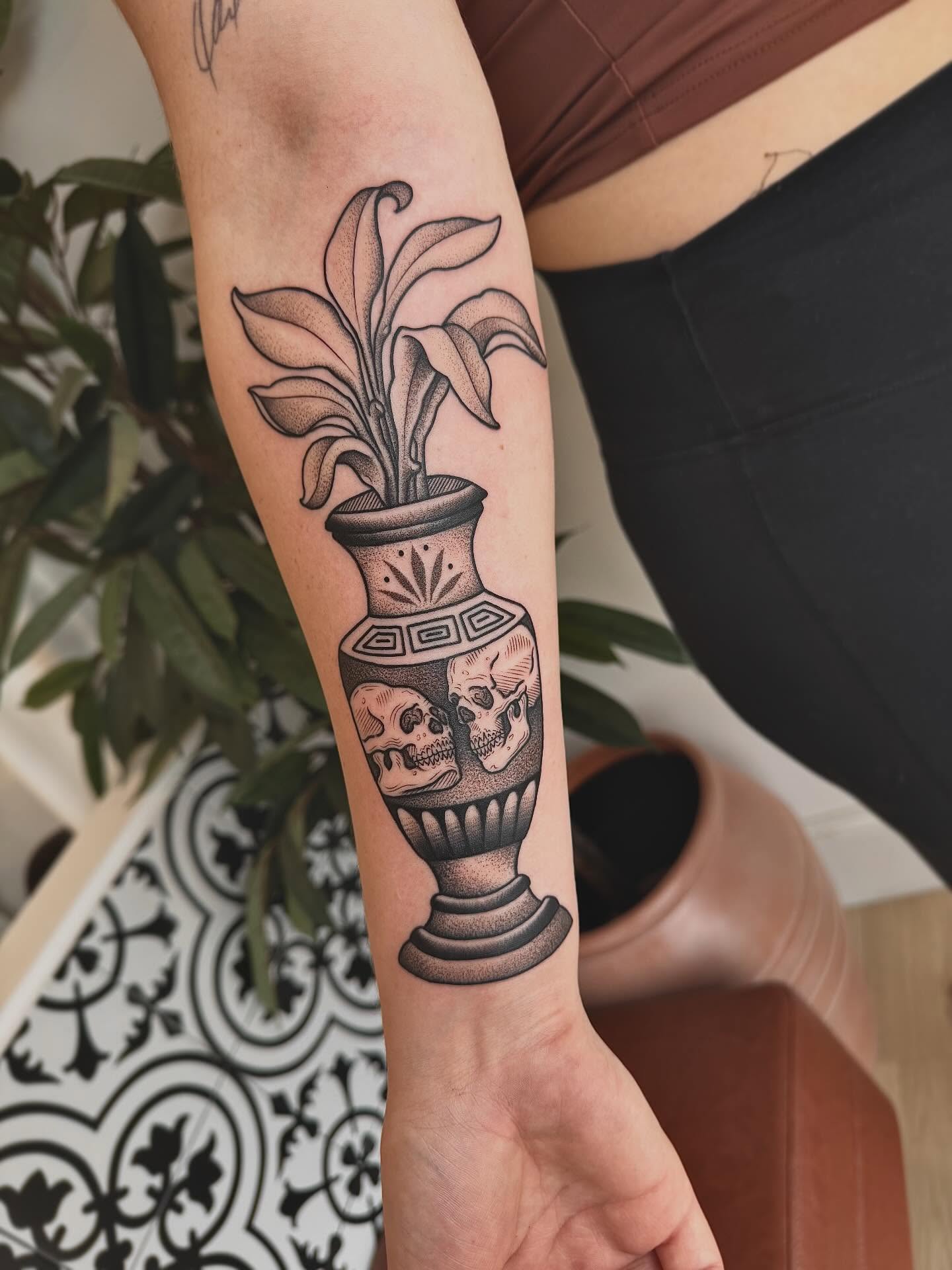 Urn with skulls and plant geometric tattoo on the forearm by Stefany