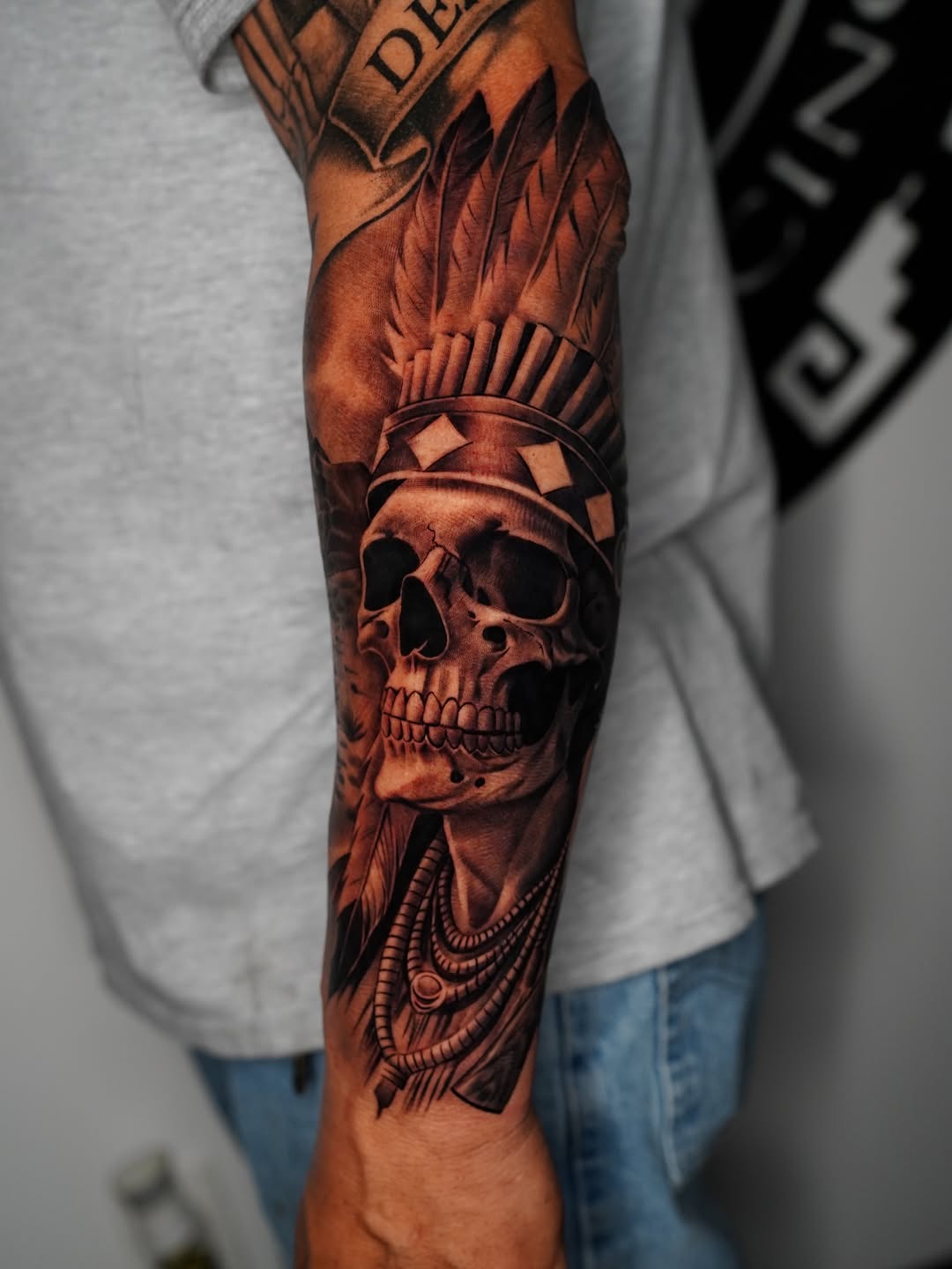 Skull with headdress and necklace realism tattoo on the forearm by Salvador Saenz Jr, Dallas, Texas