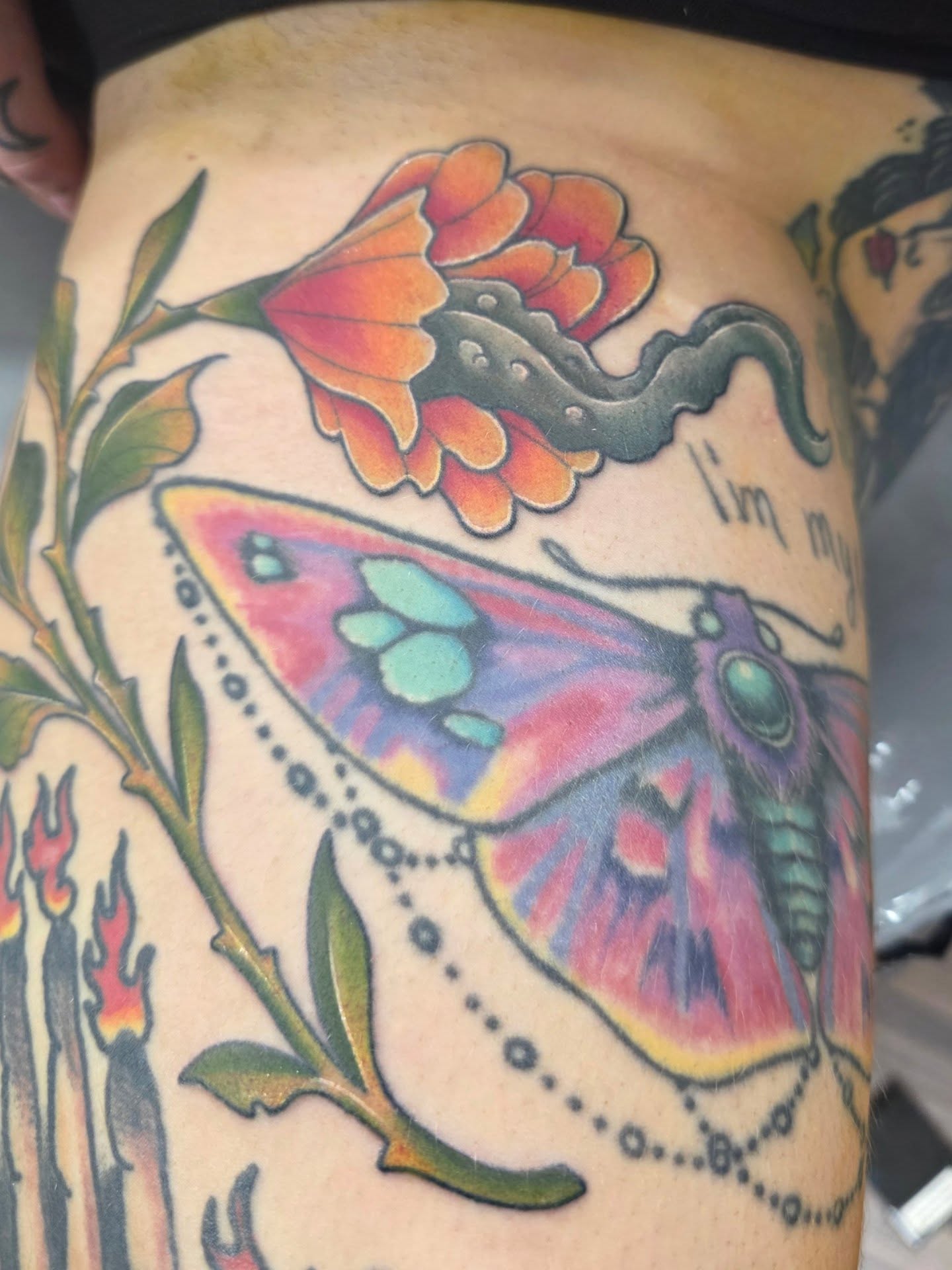 Butterfly and flower American traditional tattoo on the thigh by Mandy Rizzuto
