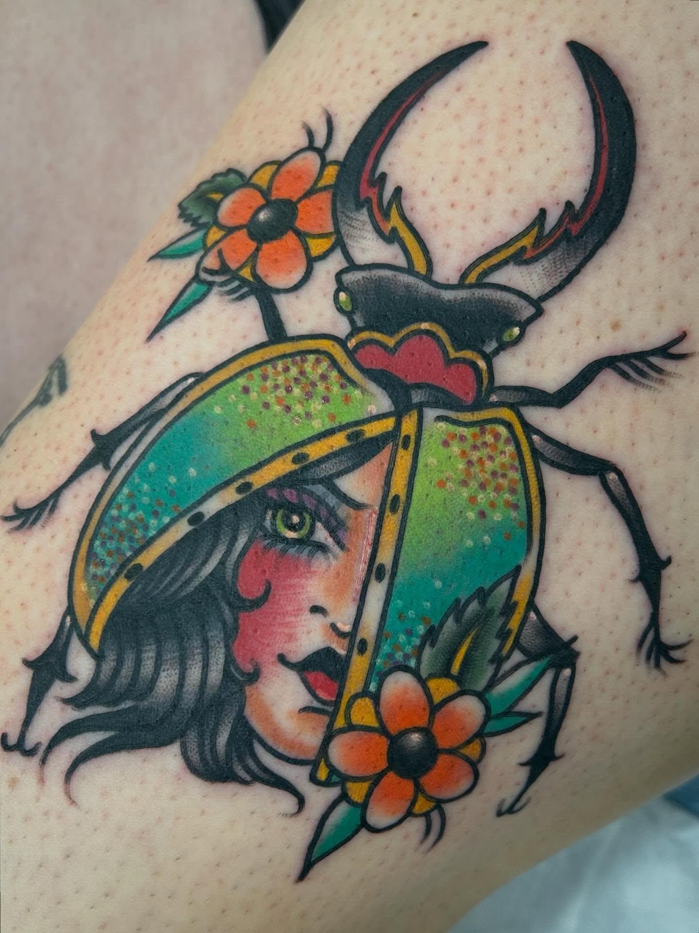 Scarab beetle with woman's face American traditional tattoo on the thigh by Morgan Hazer Tattoos, Cedar Rapids, Iowa