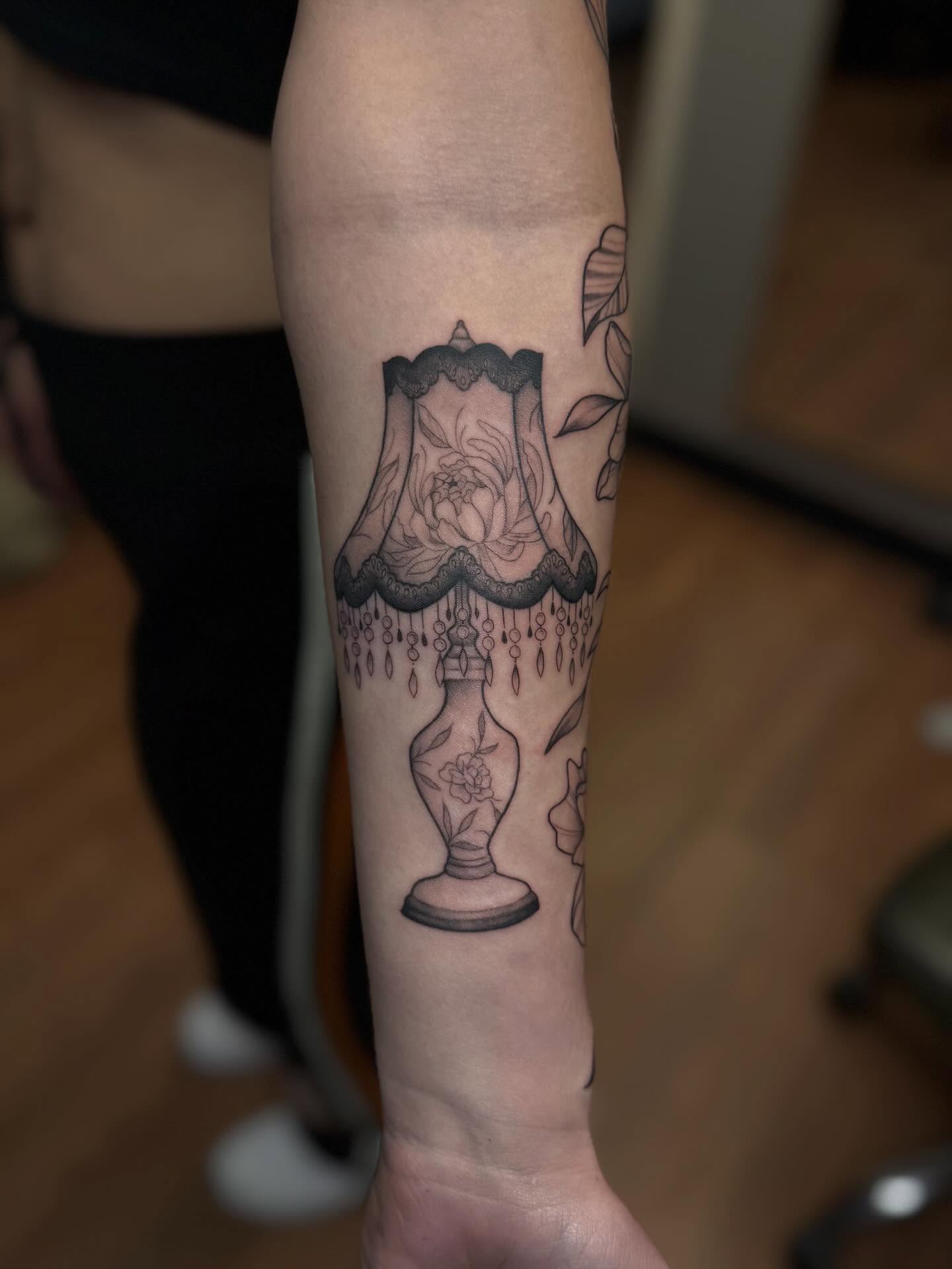 Lampshade and bottle black and grey tattoo on the forearm by Anna