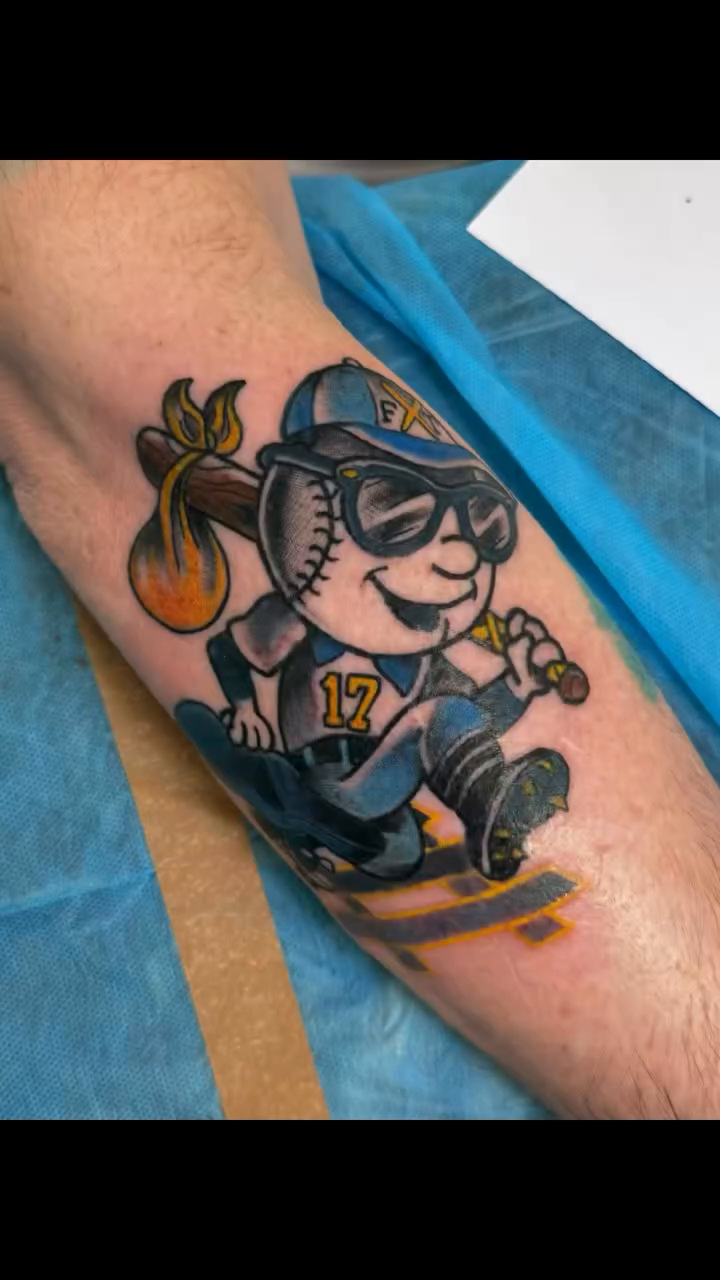 Cartoon baseball player on a skateboard tattoo on the forearm by Kimberly Parton- Chapel Hill Tattooer, Chapel Hill, North Carolina