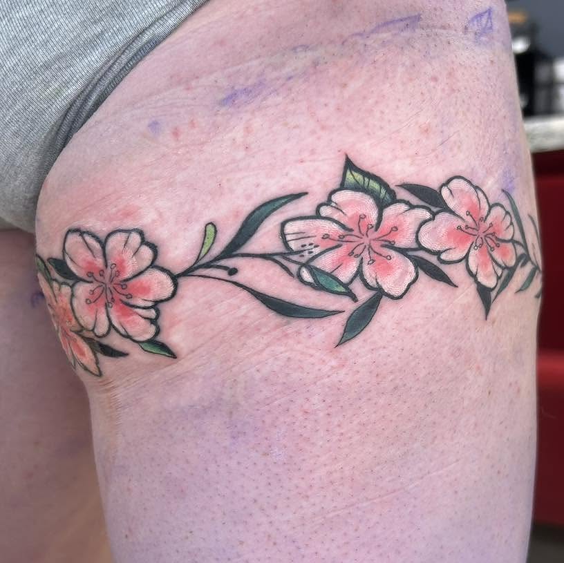 Cherry blossoms watercolor tattoo on the thigh by Nino