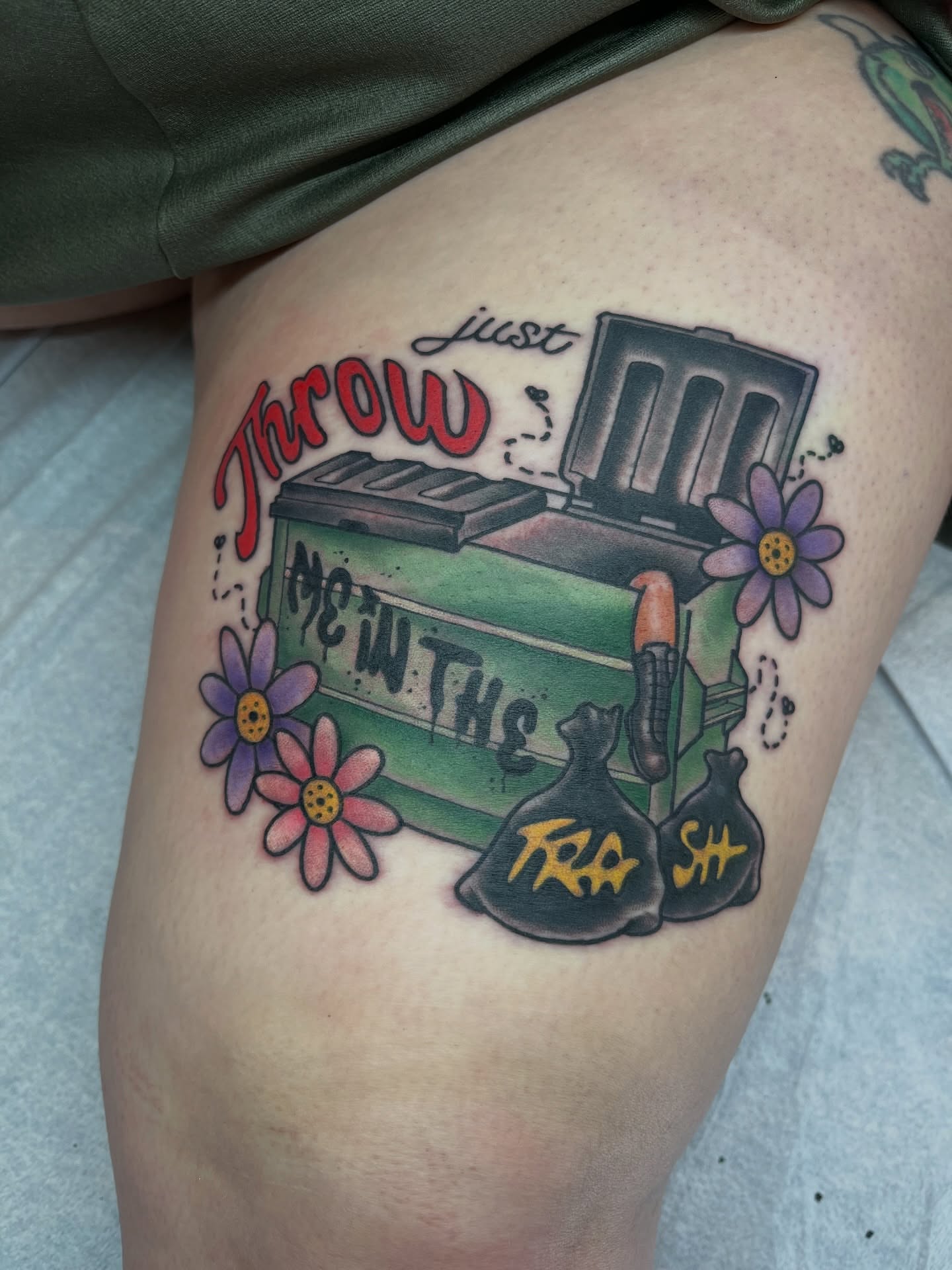 Trash can and flowers trash polka tattoo on the thigh by Kimber Teatro, Portland, Oregon