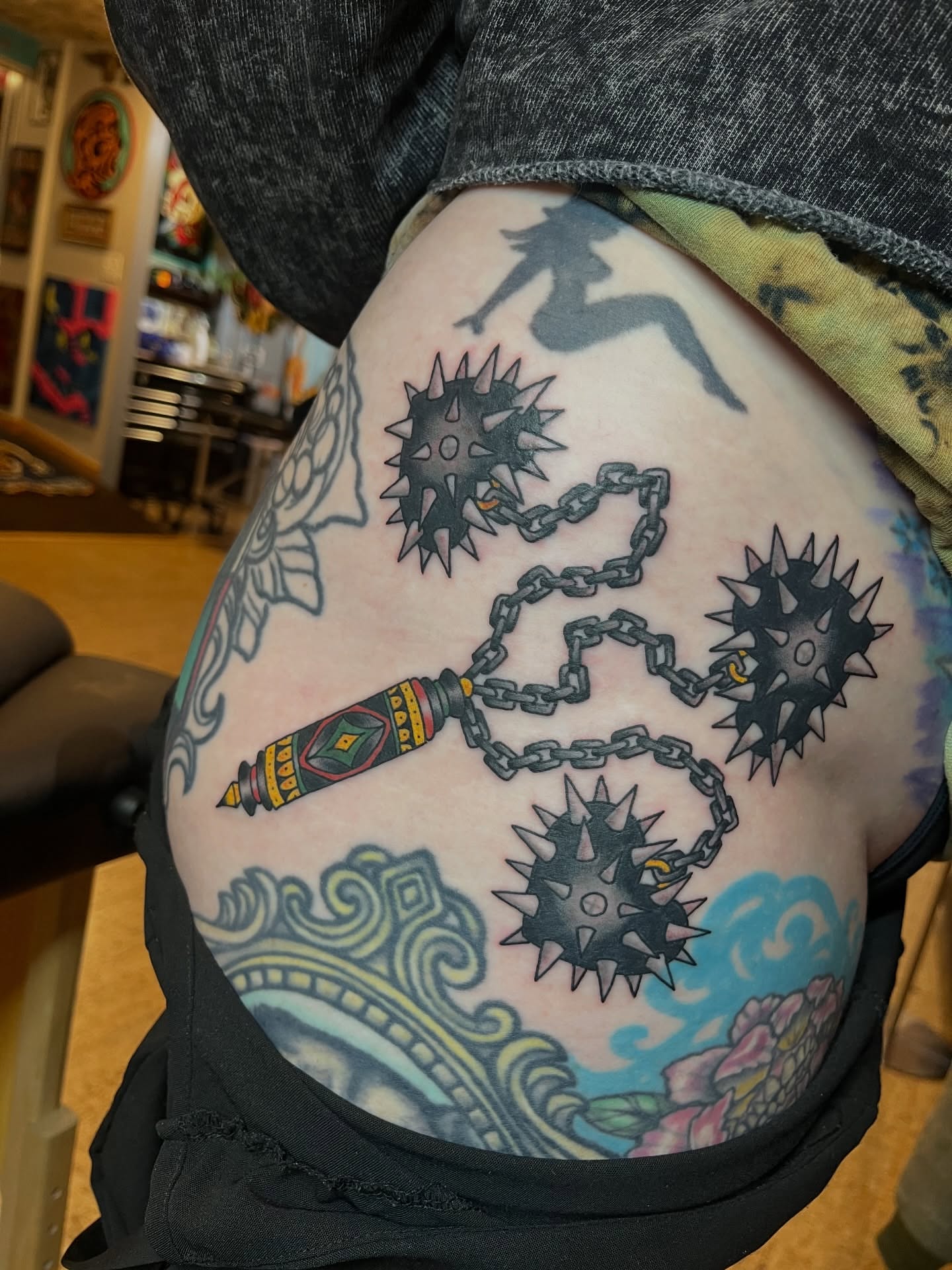 Nunchaku and spiked balls neo-traditional tattoo on the thigh by Kimber Teatro, Portland, Oregon