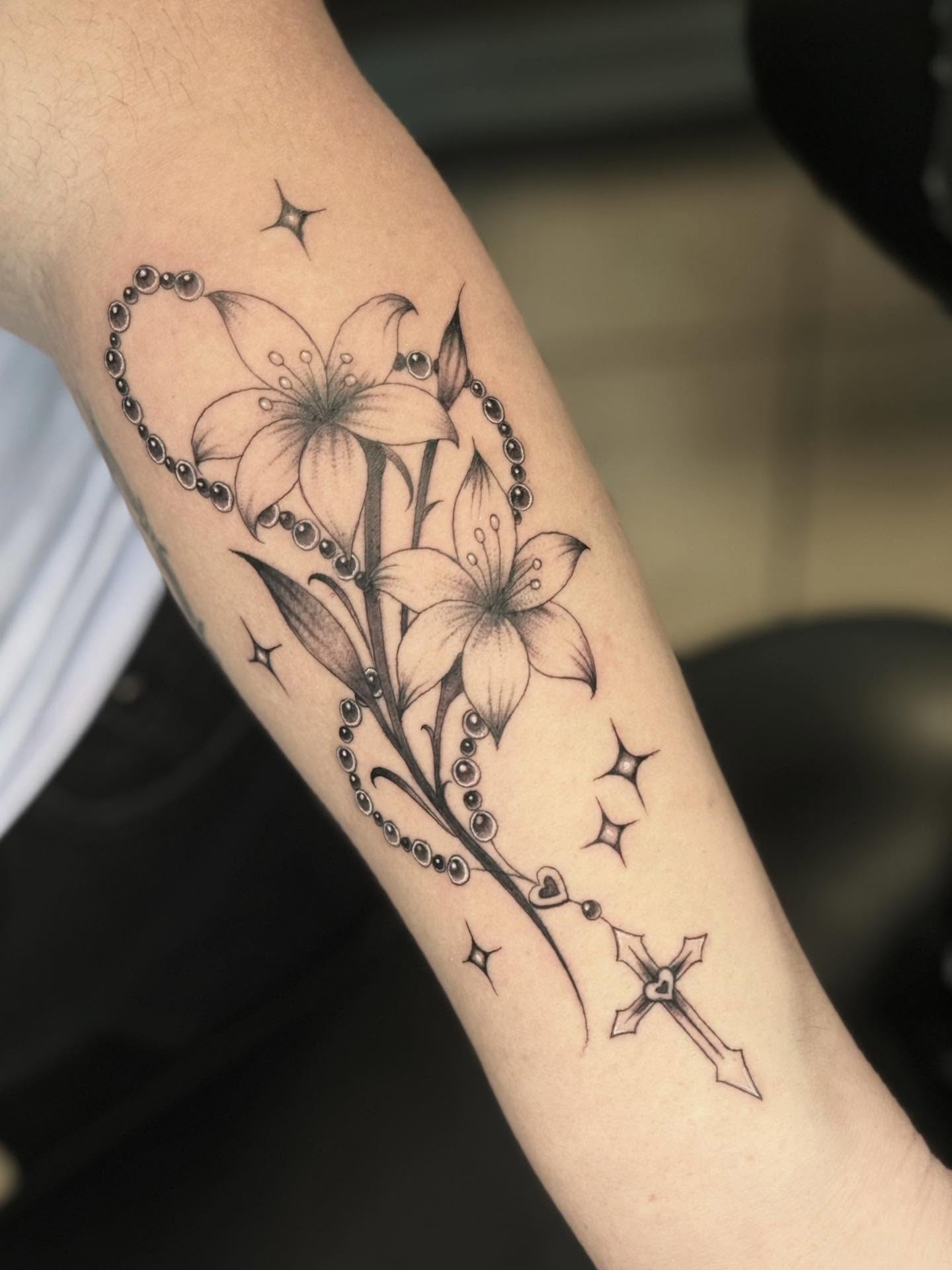 Lilies and cross black and grey tattoo on the forearm by Stilow Memphis Tattoo Artist, Memphis, Tennessee
