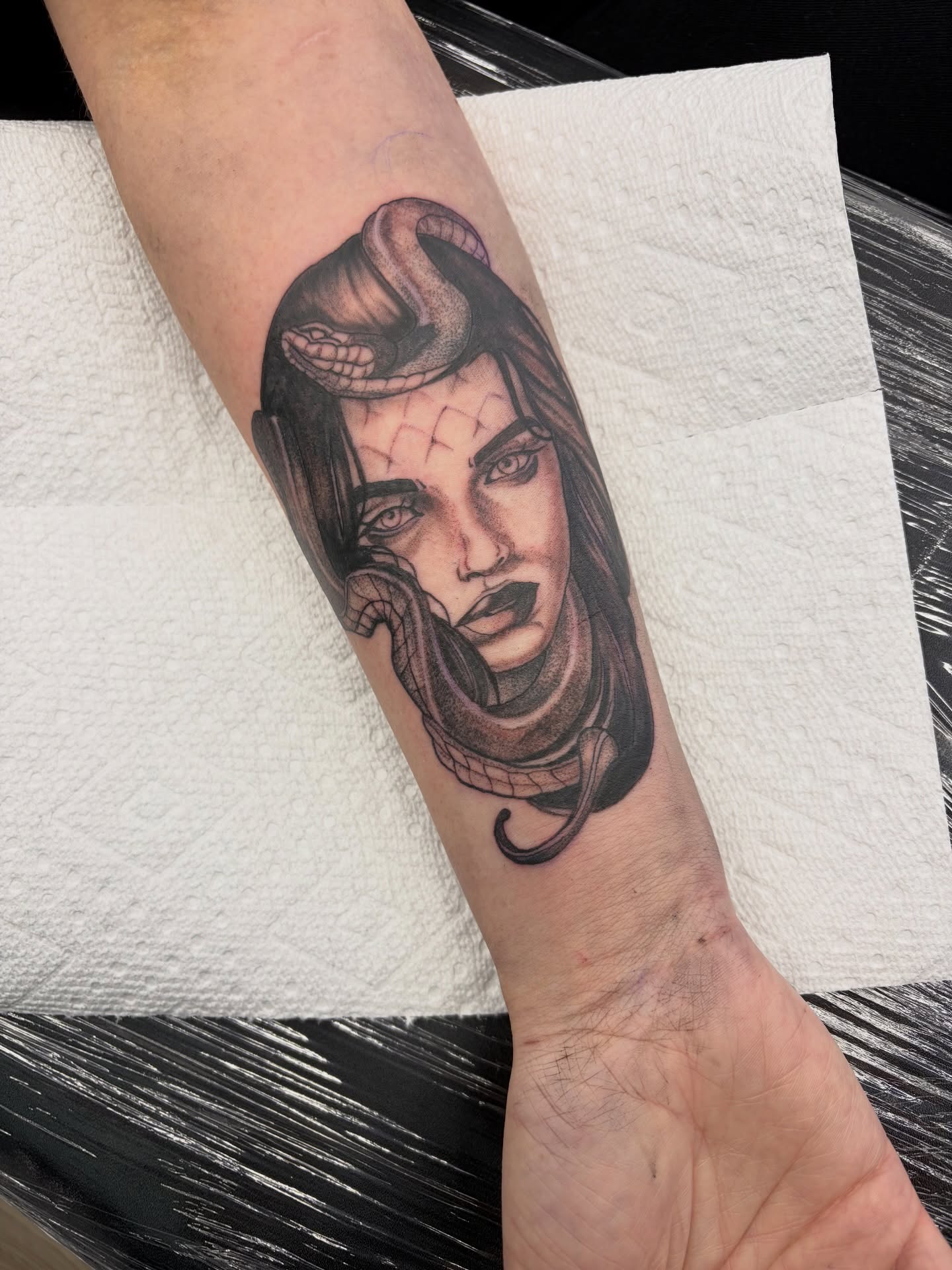 Woman with snake realism tattoo on the forearm by Calen Copeland