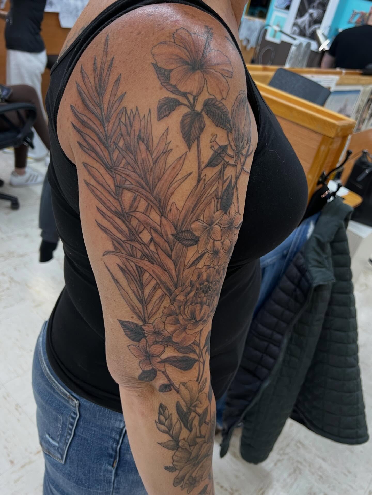Floral arrangement black and grey tattoo on the upper arm by Levi Sawdon, Everett, Washington
