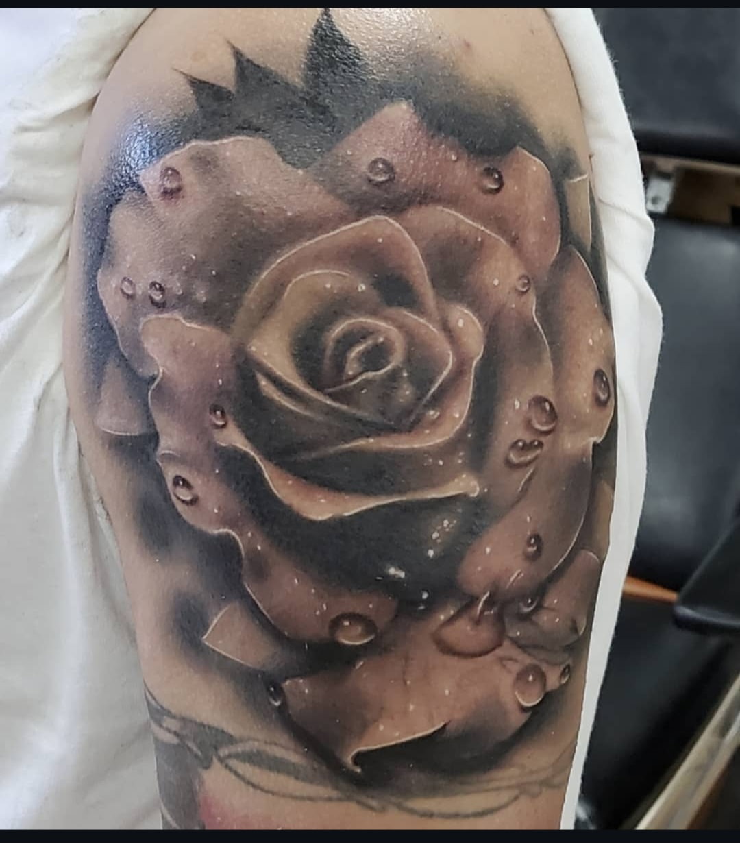 Rose realism tattoo on the upper arm by Nick Trammel