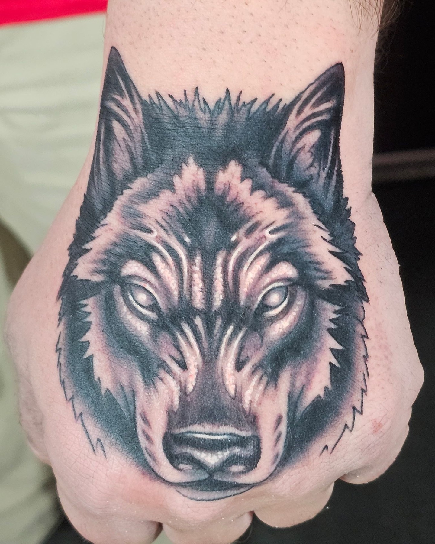 Wolf realism tattoo on the hand by Nick Trammel
