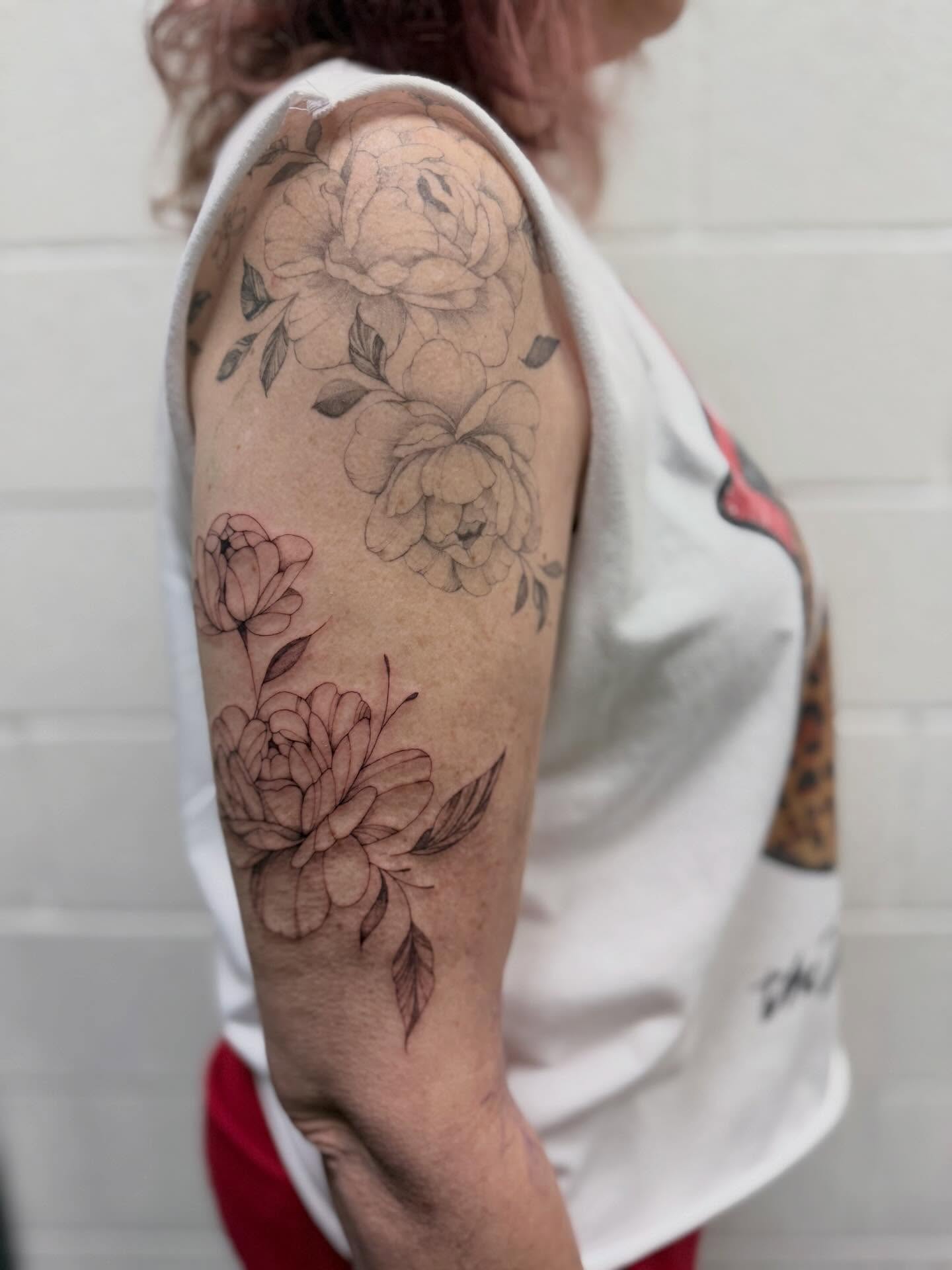 Floral bouquet black and grey tattoo on the upper arm by Reverie Studio