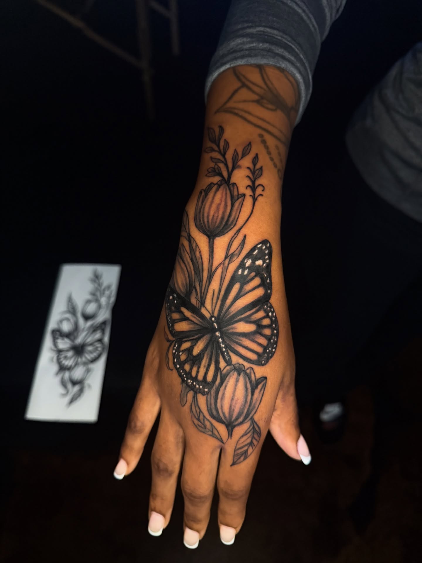 Monarch butterfly and tulips black and grey tattoo on the hand by Dallas Tattoo Artist📍