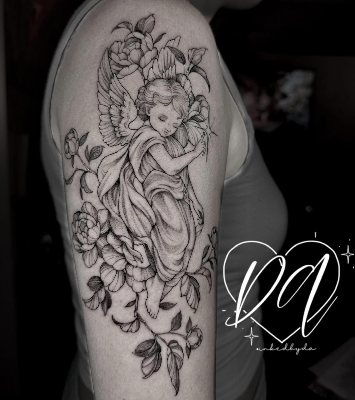 Angel with flowers realism tattoo on the upper arm by Dalton Alexandria
