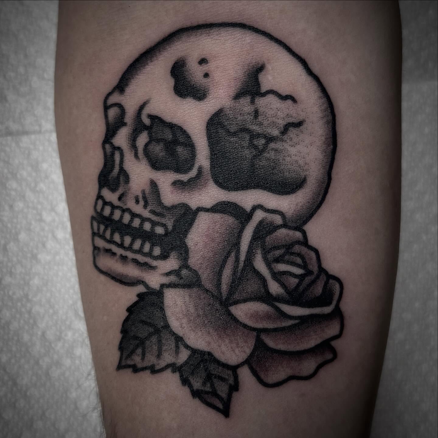 Skull and rose black and grey tattoo on the forearm by Tristan Bradshaw