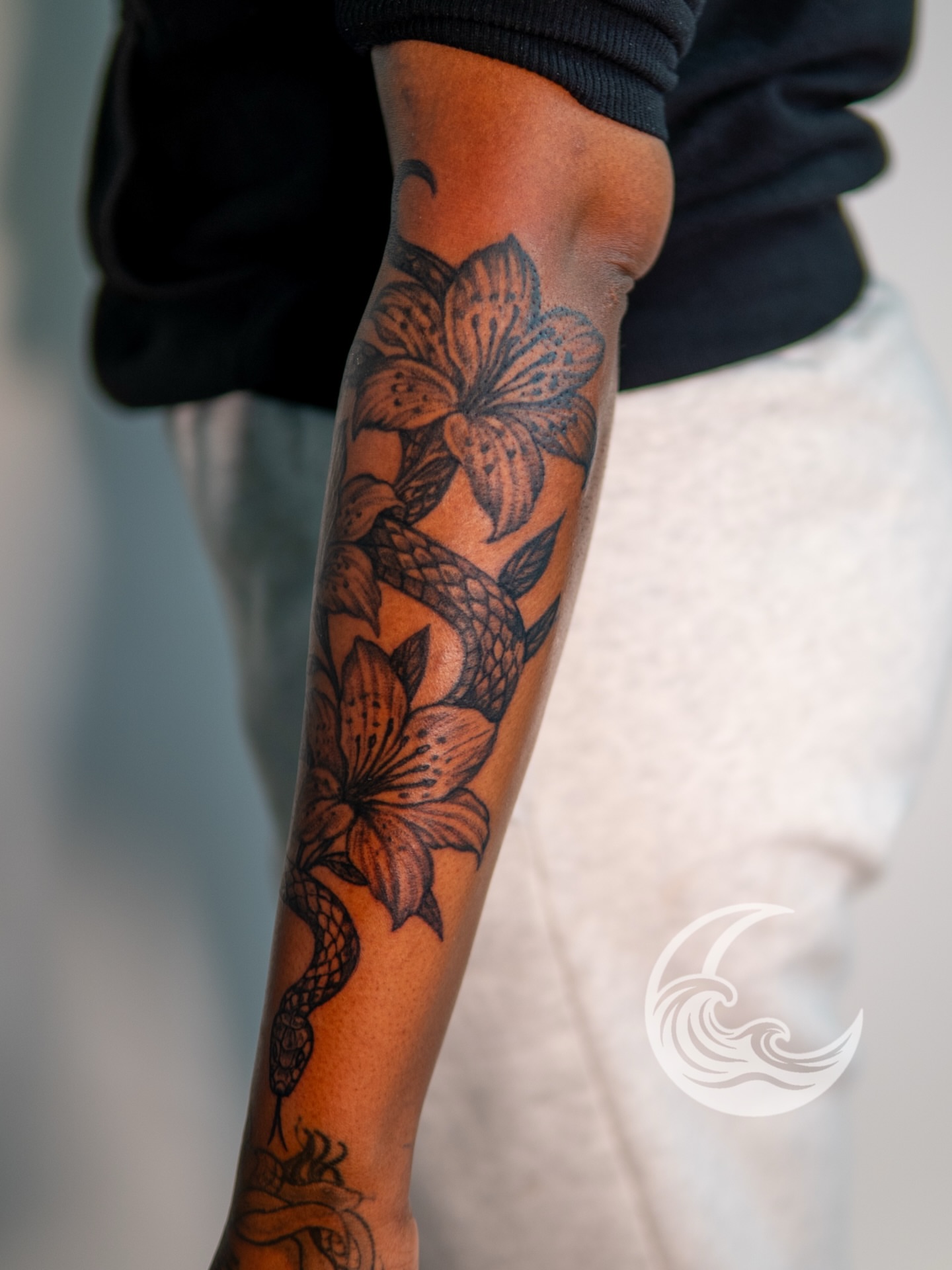 Lily and snake black and grey tattoo on the forearm by Justin custard Tattoo💉Artist 🎨Painter